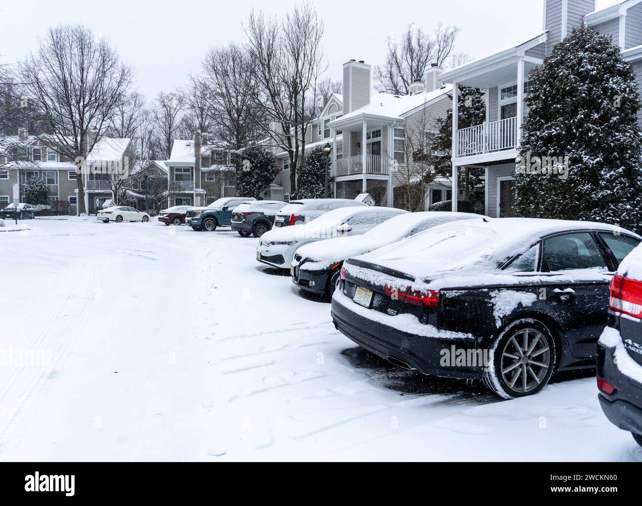 Auto coperte di neve nel parcheggio di un complesso di appartamenti Foto Stock