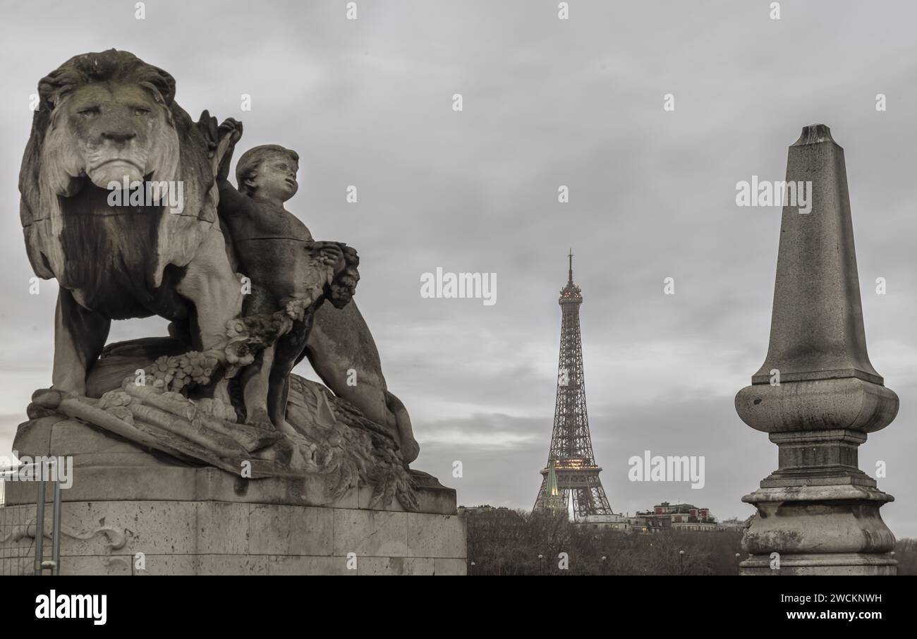 Francia, Parigi - 4 gennaio 2024 - Vista panoramica della Torre Eiffel in serata vista dal ponte Pont Alexandre-III con la Statua del Leone e lo scultore bambino Foto Stock