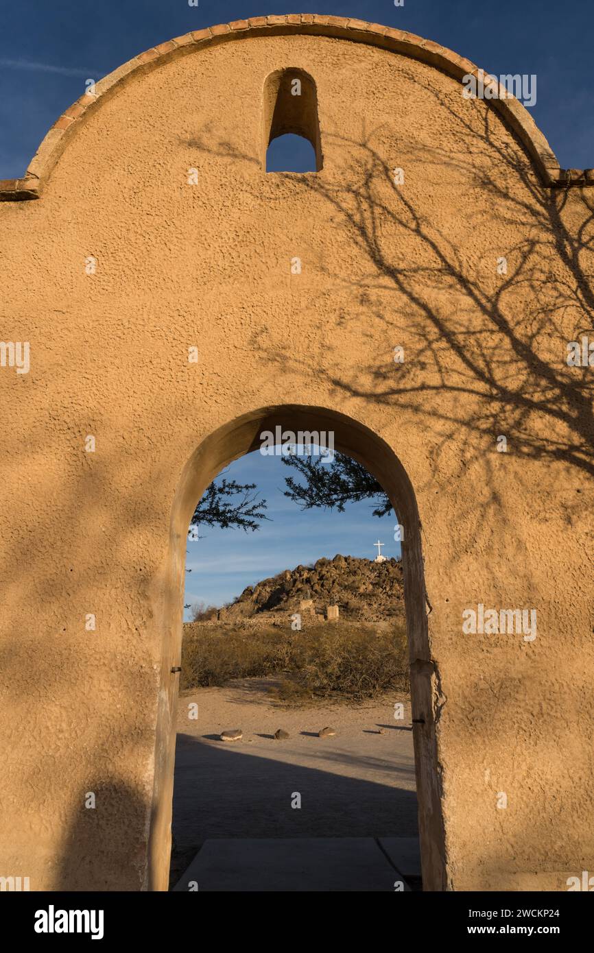 Porta ad arco attraverso il muro di protezione intorno alla missione San Xavier del Bac incornicia la Grotto Hill, Tucson Arizona. Foto Stock