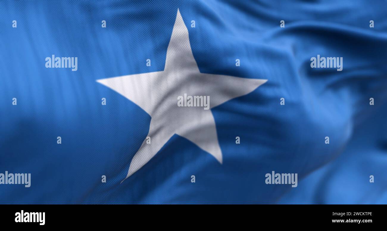Vista ravvicinata della bandiera nazionale somala che sventola nel vento. Campo azzurro con una stella bianca a cinque punte al centro. Parte posteriore in tessuto Foto Stock