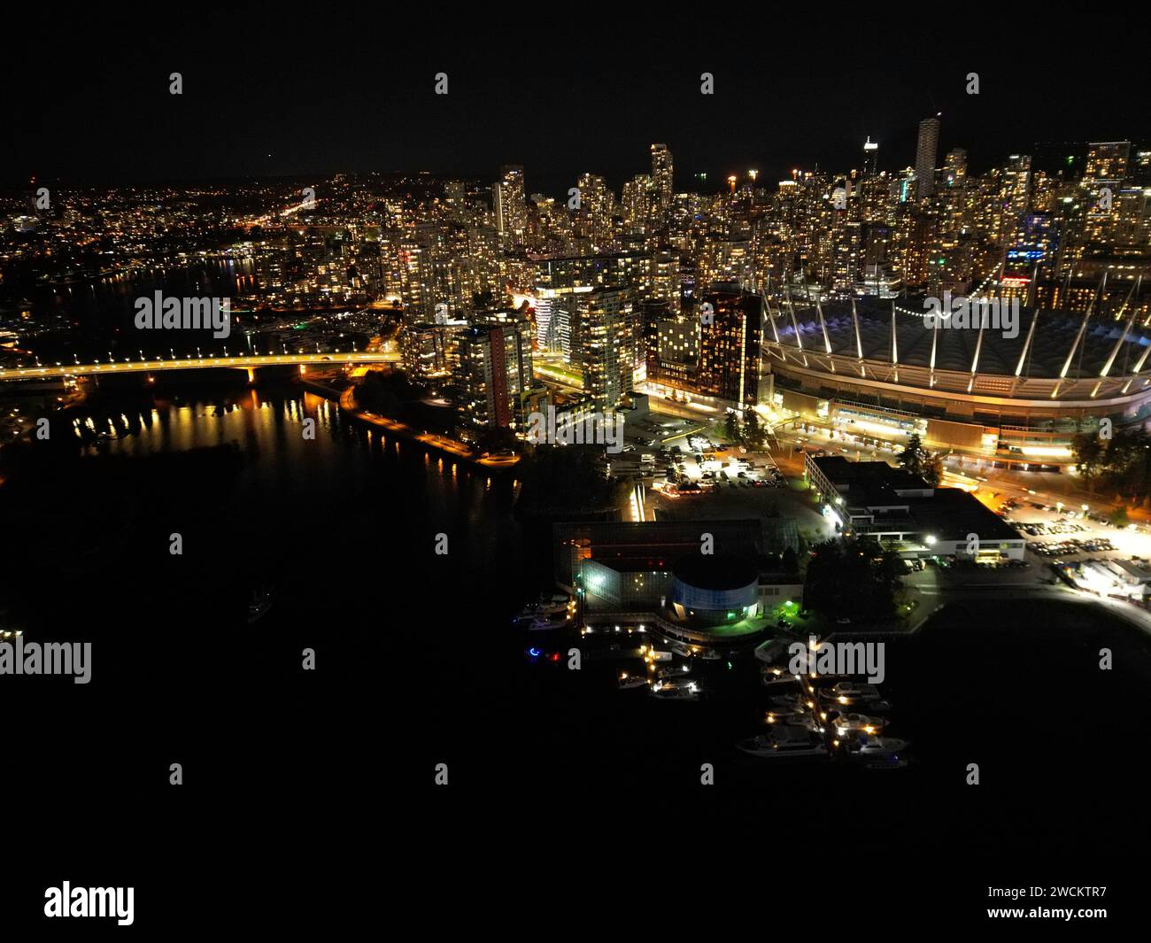 Paesaggio urbano notturno con luci che si riflettono sull'acqua Foto Stock