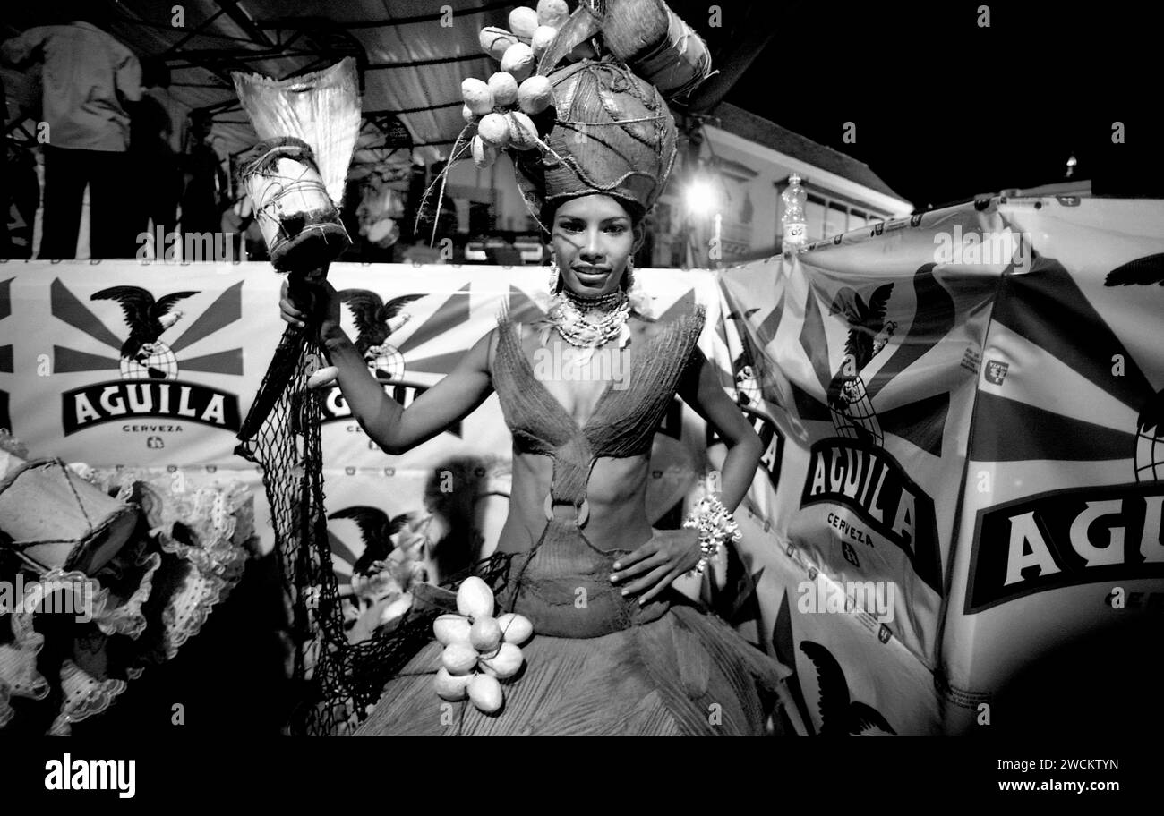 Spettacolari fotografie in bianco e nero del concorso annuale di bellezza Miss Colombia della popolazione locale a Cartagena, Colombia, i concorrenti afro-colombiani rappresentano i quartieri poveri della città. Le ragazze indossano elaborati costumi fatti in casa e copricapi di piume e sfilano le strade secondarie di Cartagena dopo il tramonto. Foto Stock