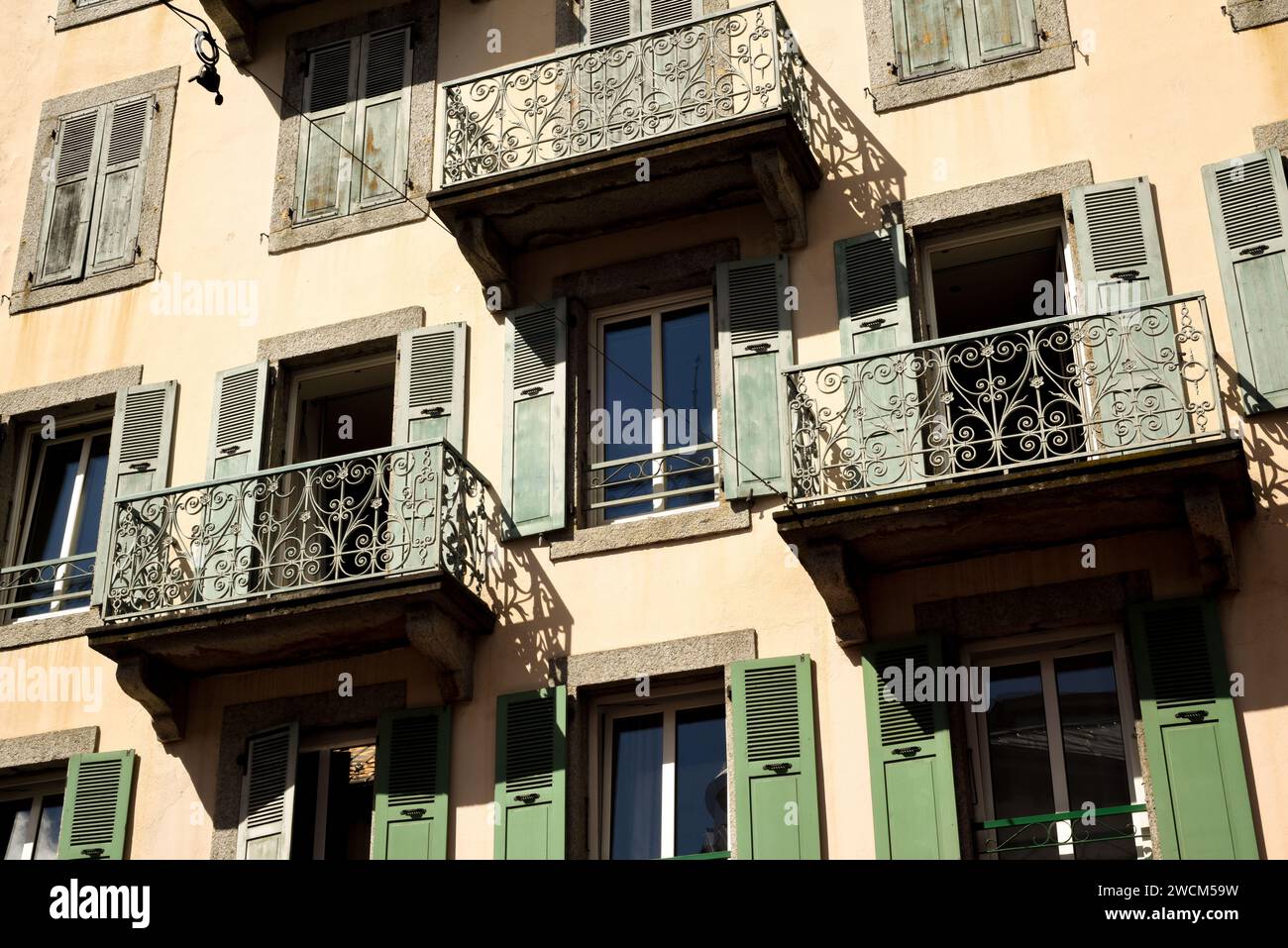 Finestre aperte e persiane su un esterno di un edificio francese in stile rustico Foto Stock