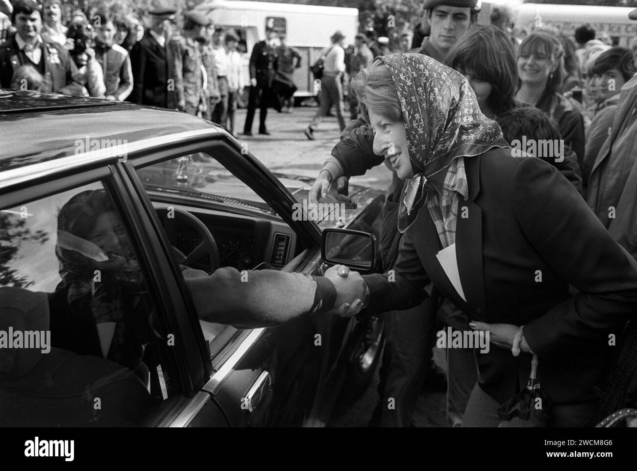 Donna che indossa un velo anni '1980 che stringe la mano del principe Carlo che guida la sua auto e lascia l'Ham Polo Club Surrey, Inghilterra 1981 UK HOMER SYKES Foto Stock