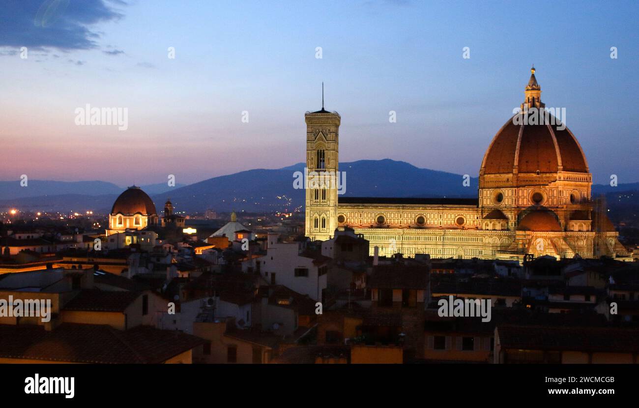 Il Duomo di Firenze sopra i tetti della città, durante la prima serata con illuminazione artificiale Foto Stock