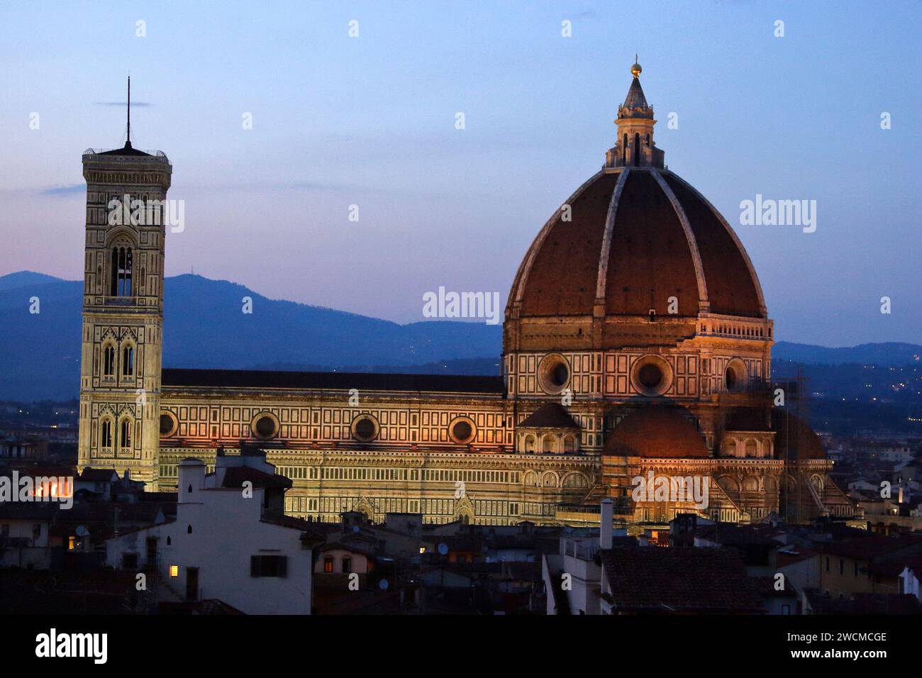Il Duomo di Firenze sopra i tetti della città, durante la prima serata con illuminazione artificiale Foto Stock