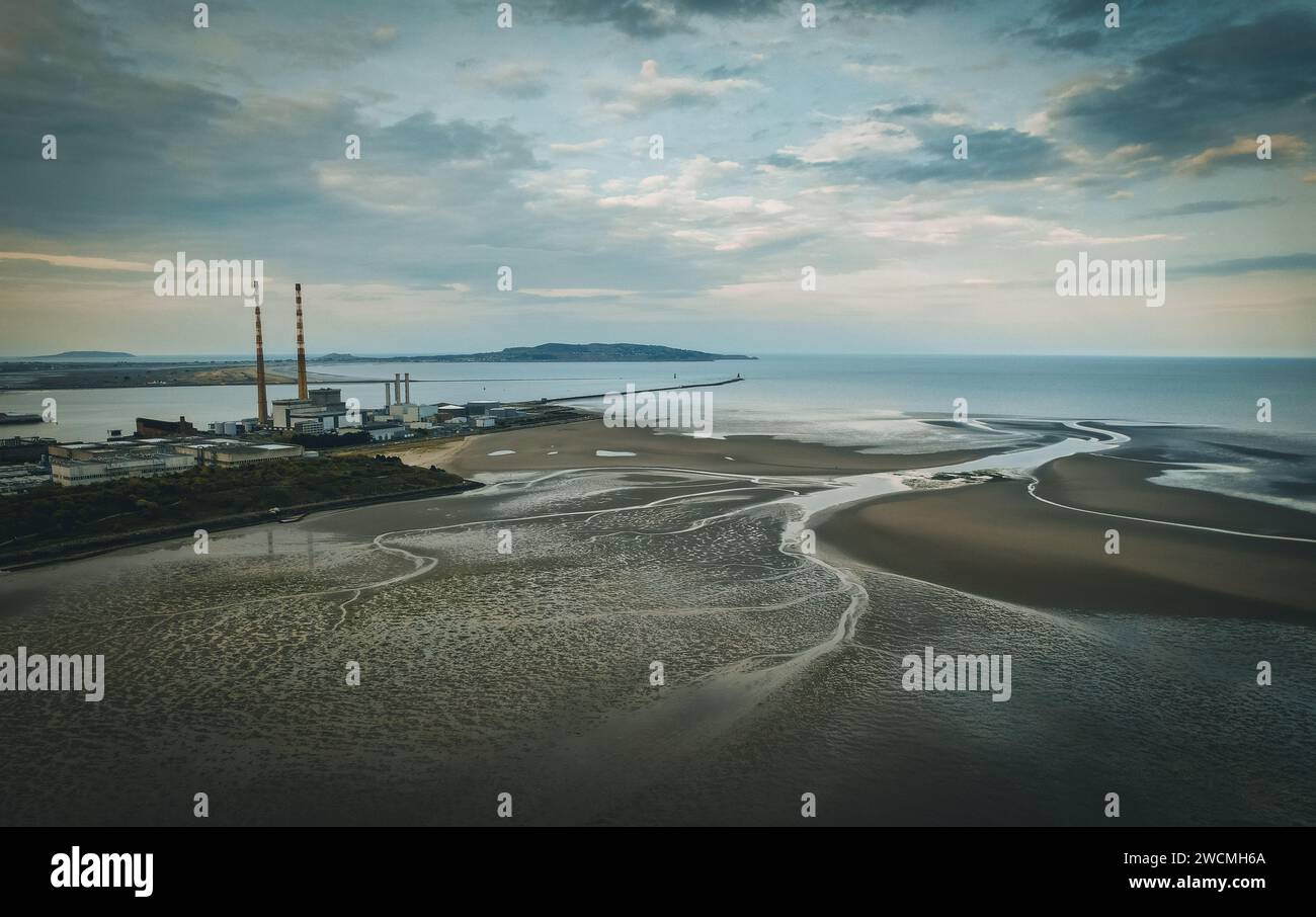 Un paesaggio costiero panoramico che mostra una spiaggia incontaminata e un porto vivace, caratterizzato da acque cristalline e da un'ampia costa sabbiosa Foto Stock