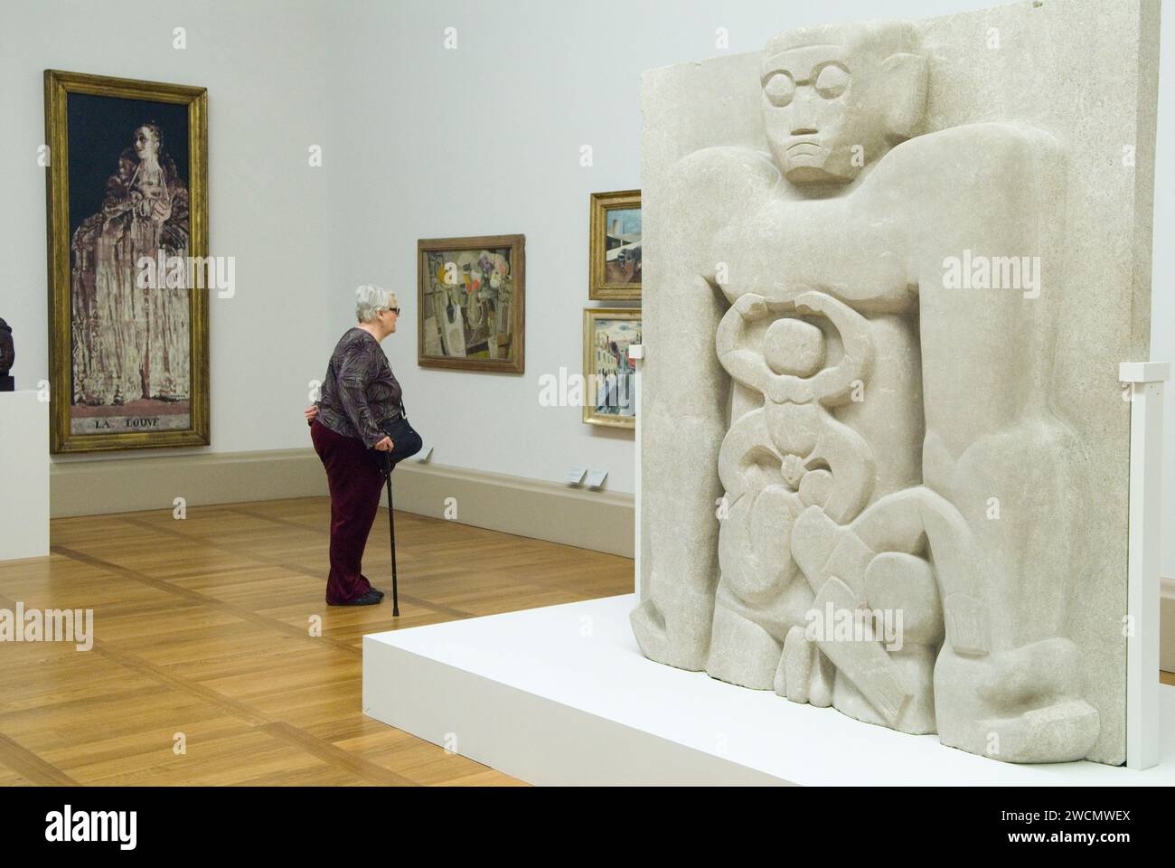Jacob Epstein artista della sua scultura Primeval Gods Older Woman che guarda l'arte nella galleria d'arte Tate Britain parte della Collezione permanente. Millbank, Londra, Inghilterra, 25 maggio 2013 2010s UK HOMER SYKES Foto Stock
