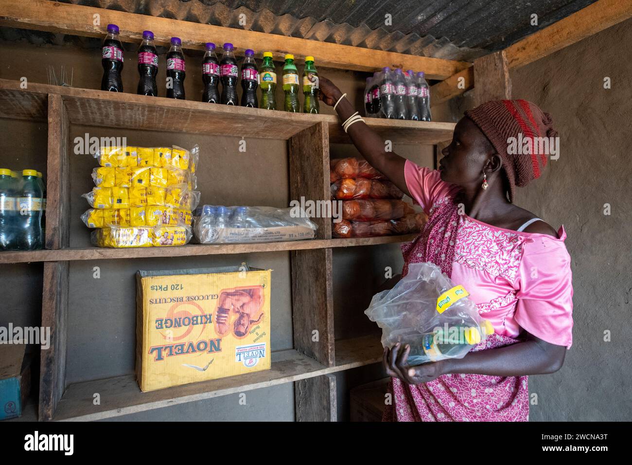 Uganda, Adjumani. Un proprietario di un negozio gestisce la sua attività dopo aver ricevuto un microprestito. Solo per uso editoriale. Foto Stock