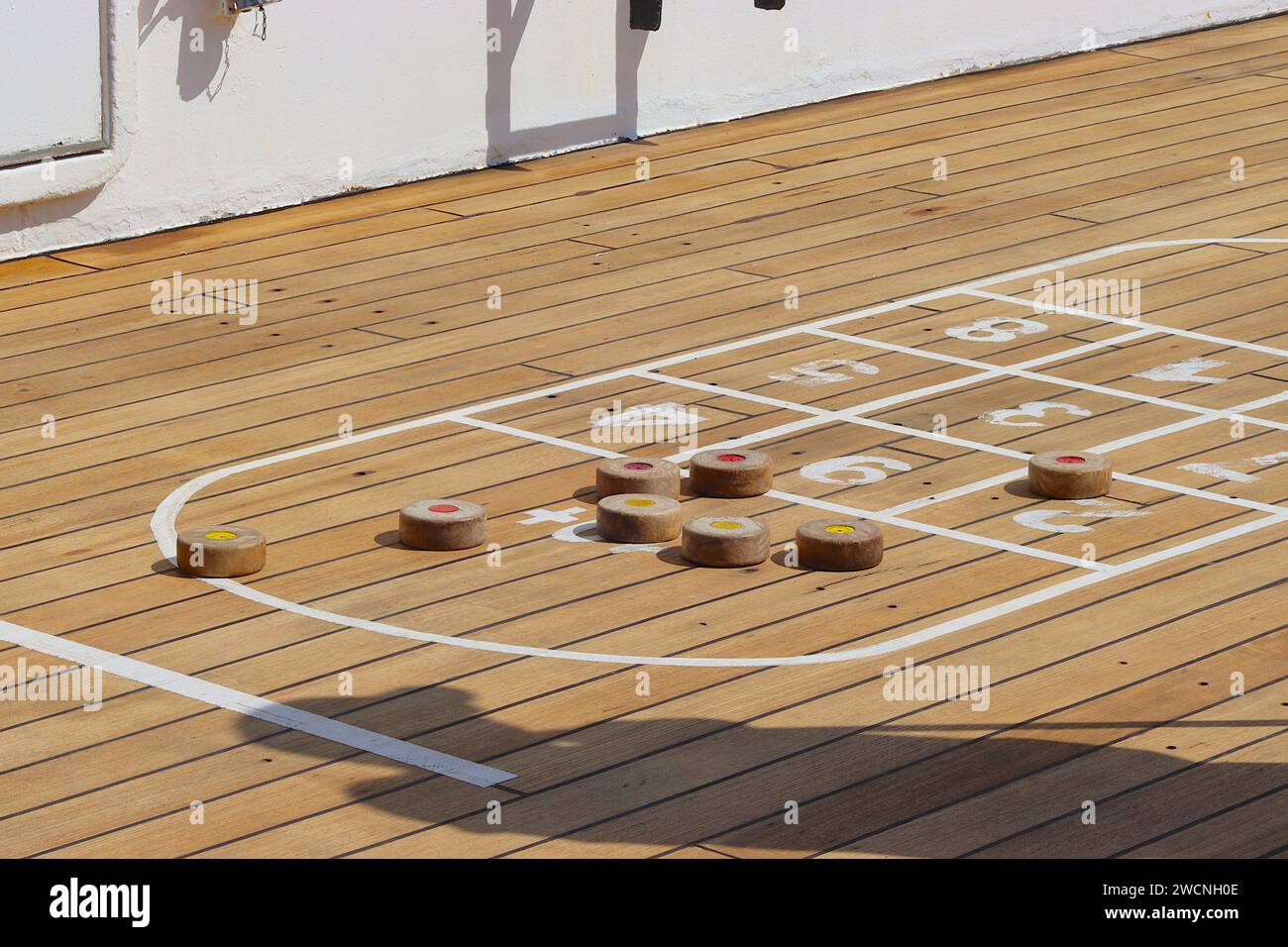 Gruppi stretti di dischi di shuffleboard illustrano la competitività durante un torneo amichevole a bordo del ponte Sun della nave da crociera Arcadia. Foto Stock