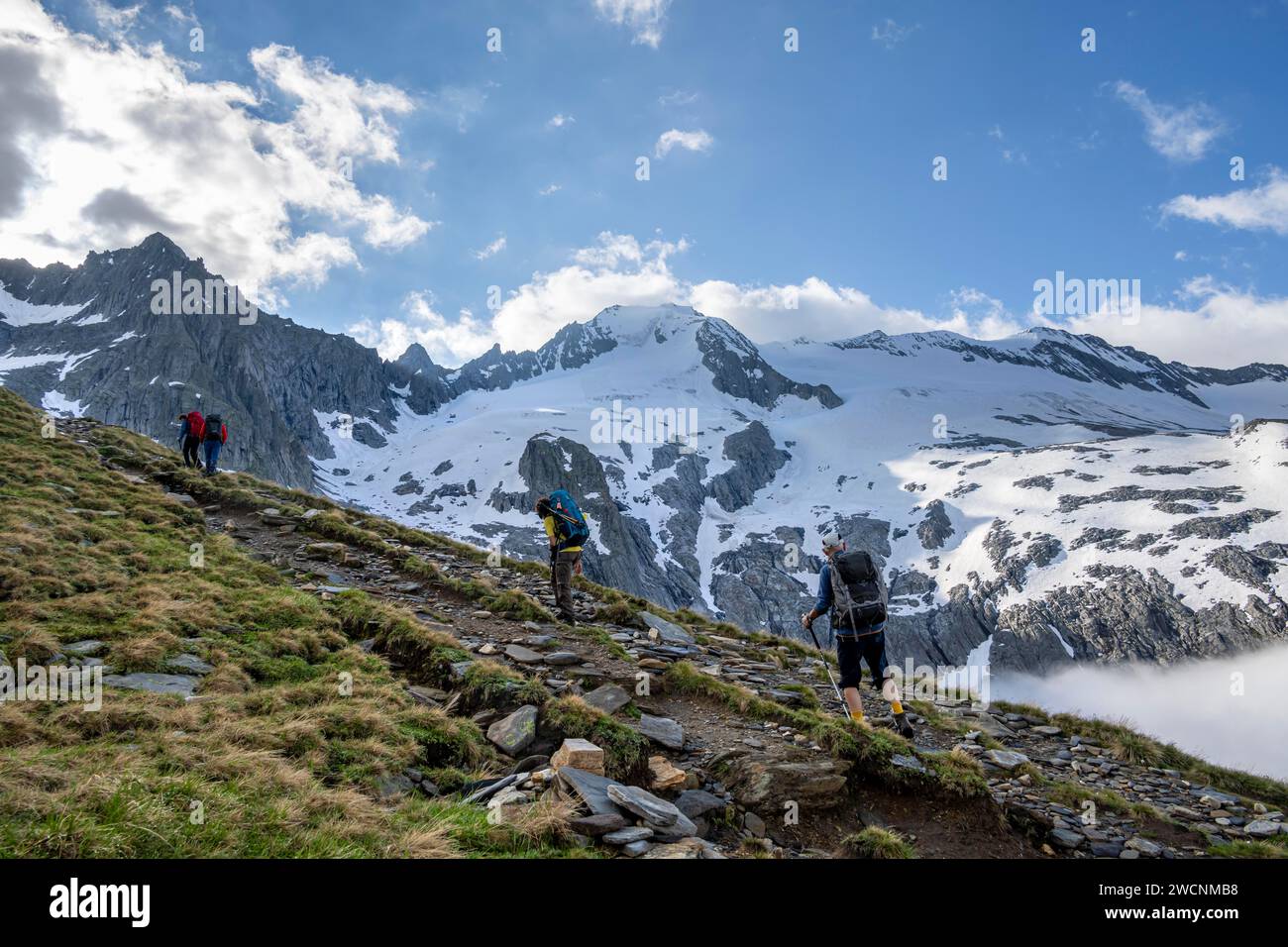 Alpinisti su un sentiero escursionistico, alta nebbia nella valle, montagne ghiacciate con Furtschagelkees, vetta Grosser Moeseler e Furtschaglspitze Foto Stock