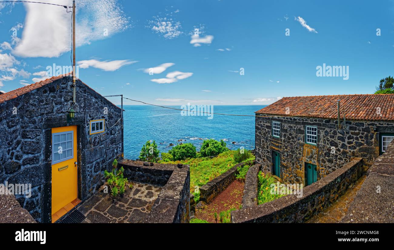 Rustiche case in pietra lavica sullo sfondo di un pittoresco mare, villaggio di pescatori, Sao Joao, Pico Island, Azzorre, Portogallo Foto Stock