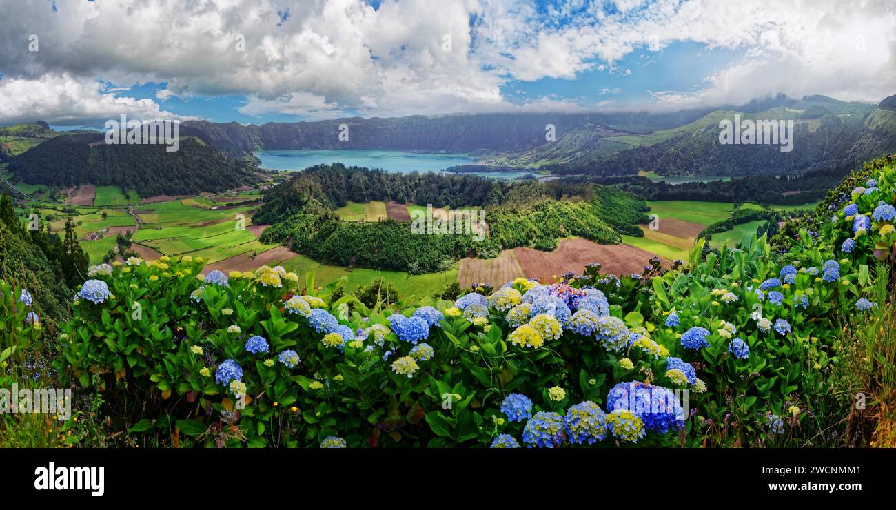 Vista panoramica del pittoresco paesaggio del cratere della Caldeira das Sete Cidades con il lago Lagoa Azul e i campi, circondati da fioritura Foto Stock