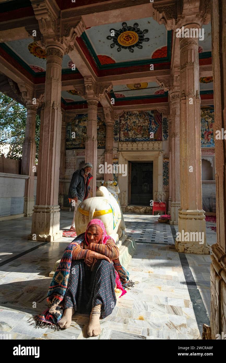 Pushkar, India - 4 gennaio 2024: Una coppia di anziani in un piccolo tempio indù nella città vecchia di Pushkar, India. Foto Stock