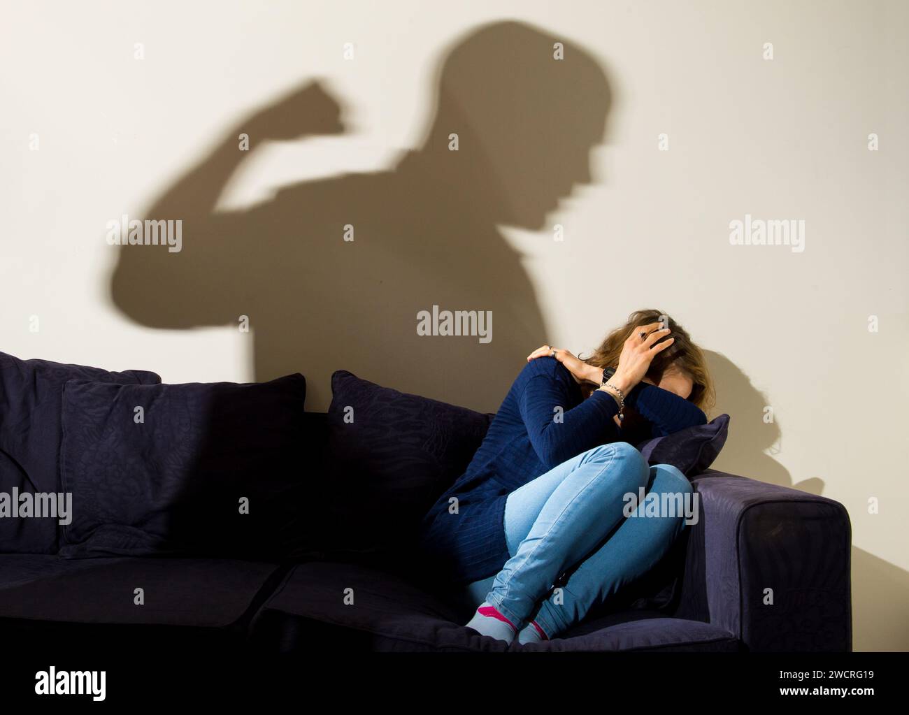 IMMAGINE POSTA DA Un MODELLO file foto datata 09/03/15 di un'ombra di un uomo con un pugno chiuso come una donna copre nell'angolo. La più grande società immobiliare britannica ha affermato che offrirà spazi sicuri alle persone che subiscono abusi domestici. La Nationwide Building Society ha dichiarato che offrirà spazi sicuri alle persone che subiscono abusi domestici in più di 400 filiali in tutto il Regno Unito. L'anno scorso la società ha promesso che ovunque abbia un ramo, sarà ancora lì almeno fino al 2026. Data di emissione: Mercoledì 17 gennaio 2024. Foto Stock