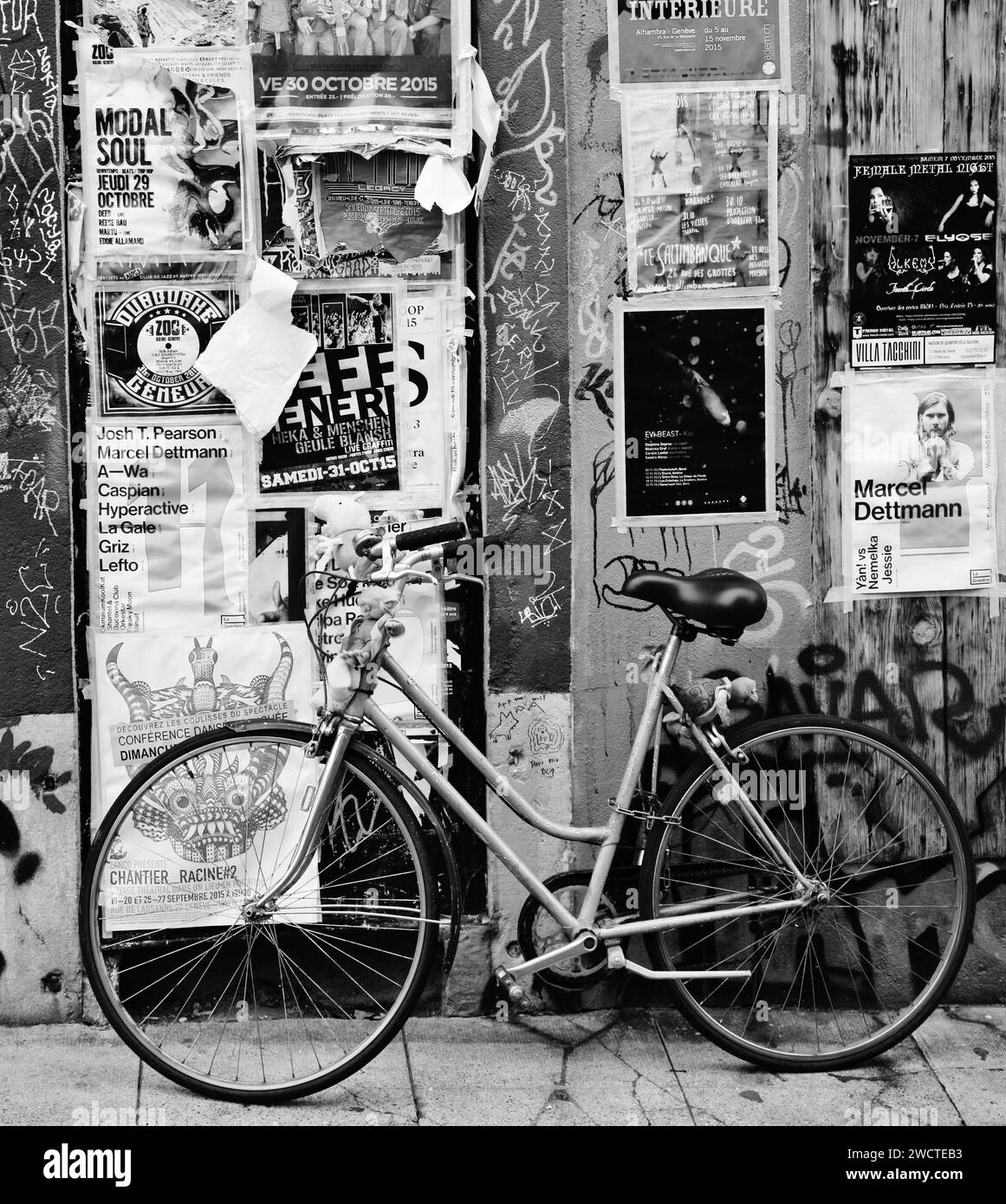 Una bicicletta retrò d'epoca si appoggia a un poster e a una parete coperta di graffiti Foto Stock