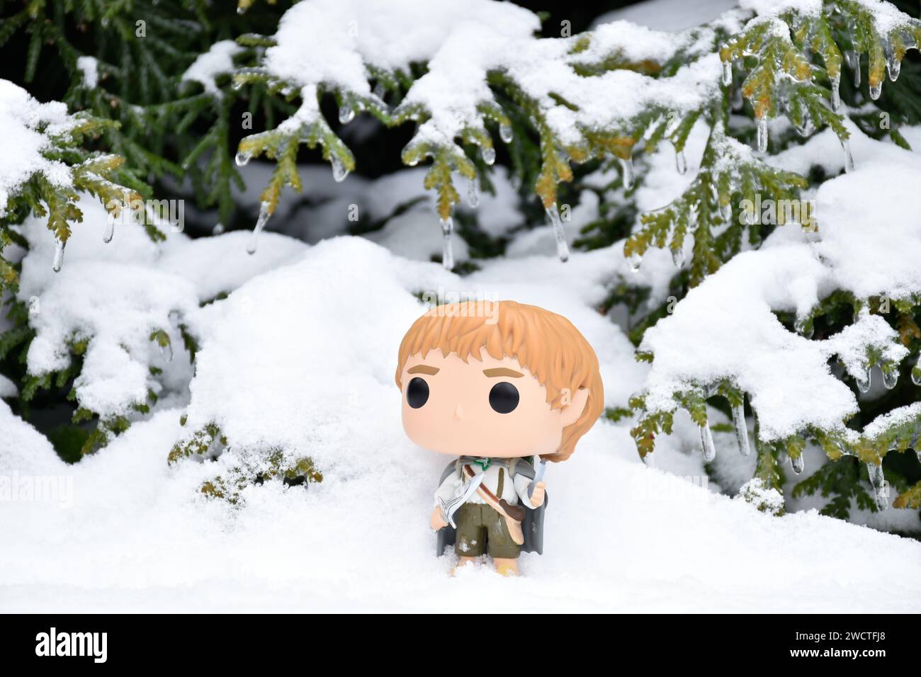 Funko Pop action figure di hobbit Sam con spada e luce di fiala tratta dal film fantasy il Signore degli anelli. Foresta invernale, piste innevate, boschi verdi. Foto Stock