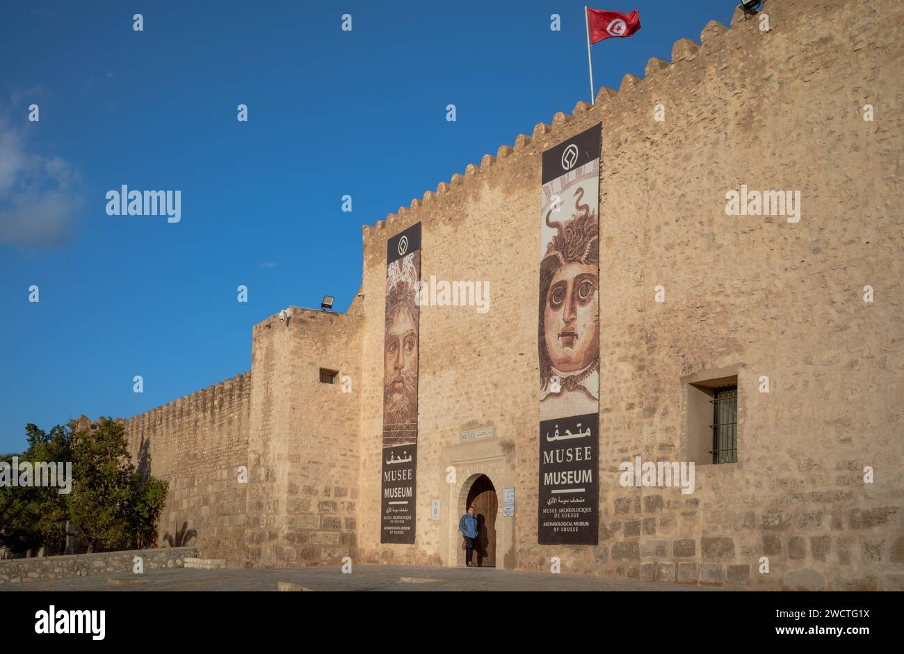 Una bandiera tunisina vola sopra l'ingresso del Museo Archeologico della Kasbah nella medina di Sousse. La zona è un sito patrimonio dell'umanità dell'UNESCO. Foto Stock