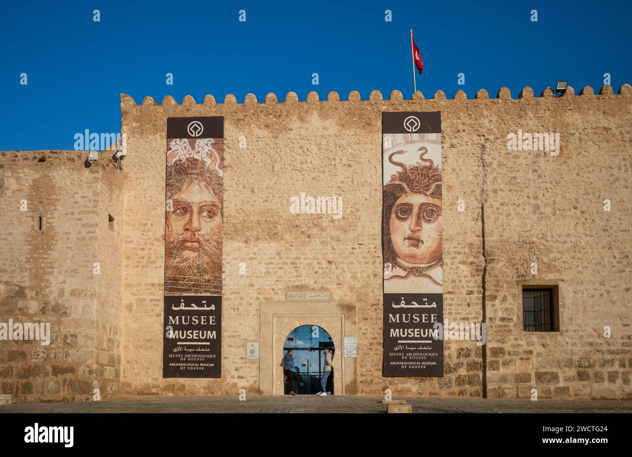 Una bandiera tunisina vola sopra l'ingresso del Museo Archeologico della Kasbah nella medina di Sousse. La zona è un sito patrimonio dell'umanità dell'UNESCO. Foto Stock