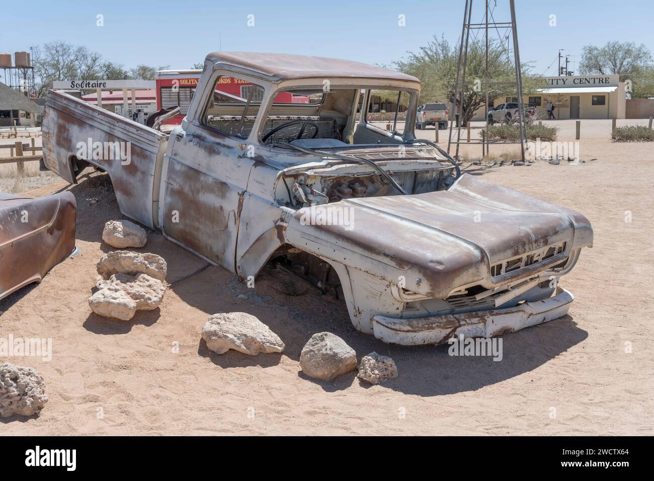 Il relitto della carrozzeria di un'auto d'epoca degli anni '50 consumato dalla ruggine in mostra presso la stazione di rifornimento nel deserto di Naukluft, sparato in una luce brillante di tarda primavera al Solitaire, Foto Stock