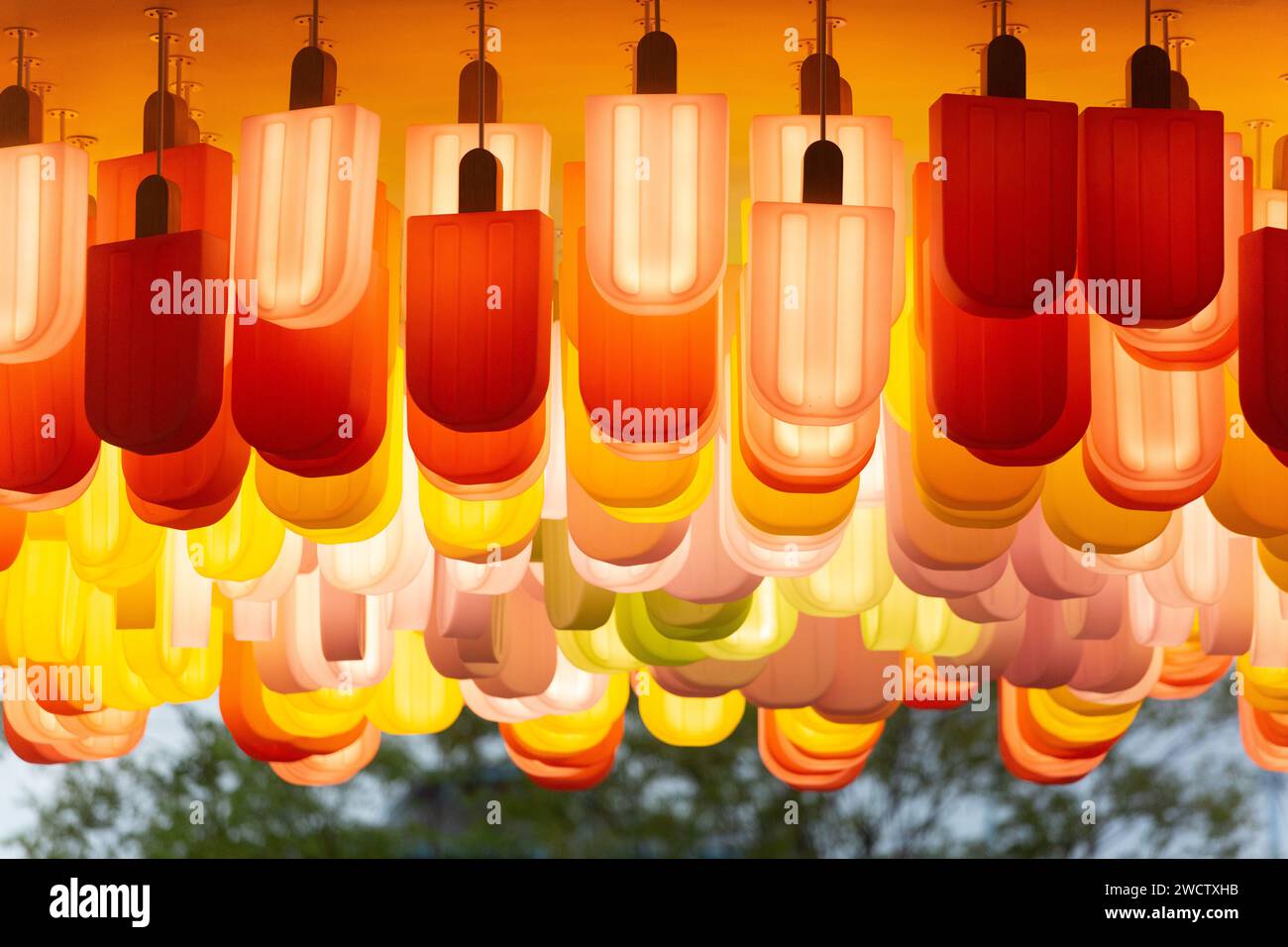 Popsicle è appeso a testa in giù, ma è una decorazione di espositori per apparecchi di illuminazione che attira i clienti per affari. Resort World Sentosa, Singapore. Foto Stock