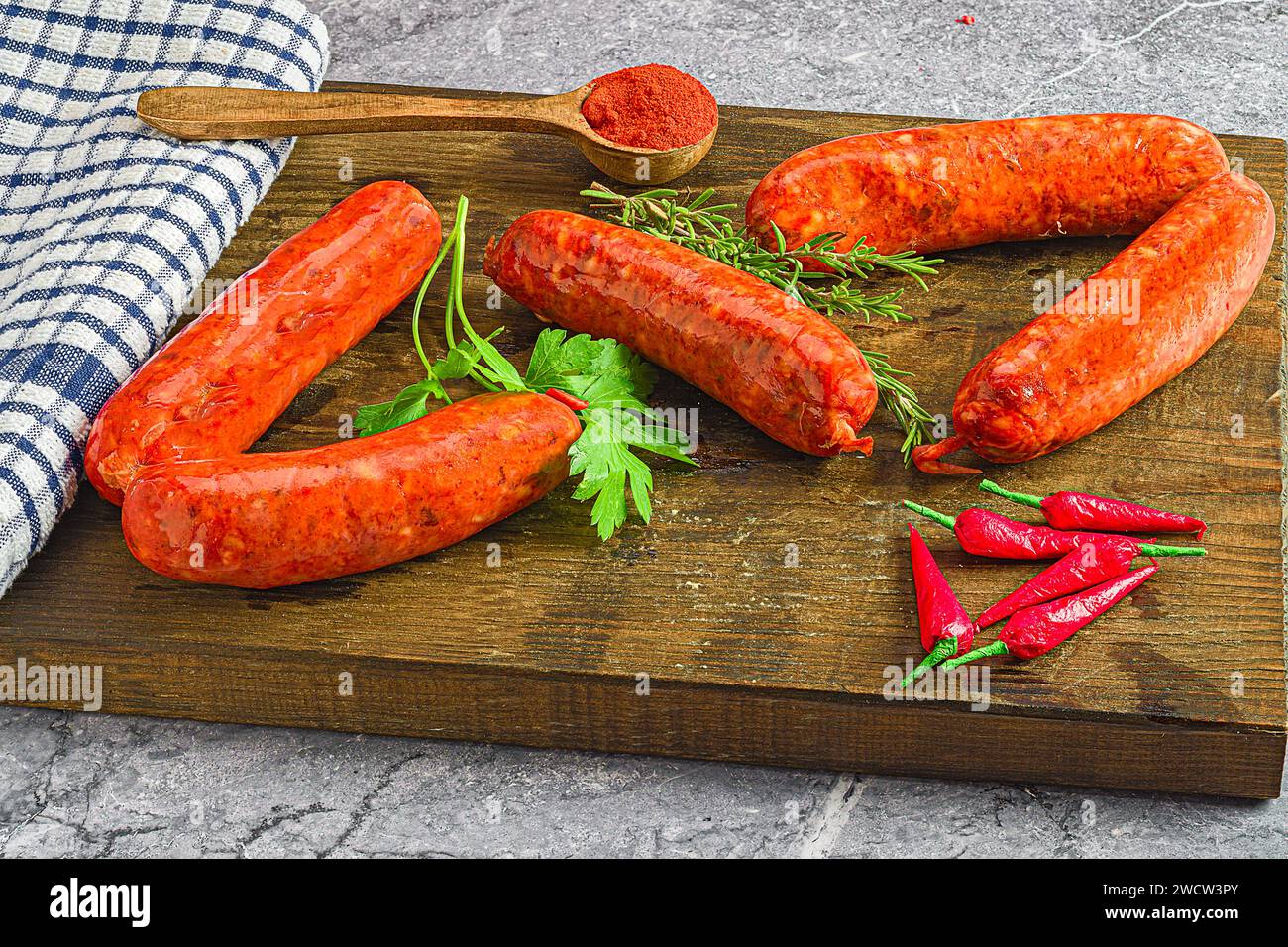 Gli hot dog assortiti adornati con erbe aromatiche e peperoni su una tavola di legno Foto Stock