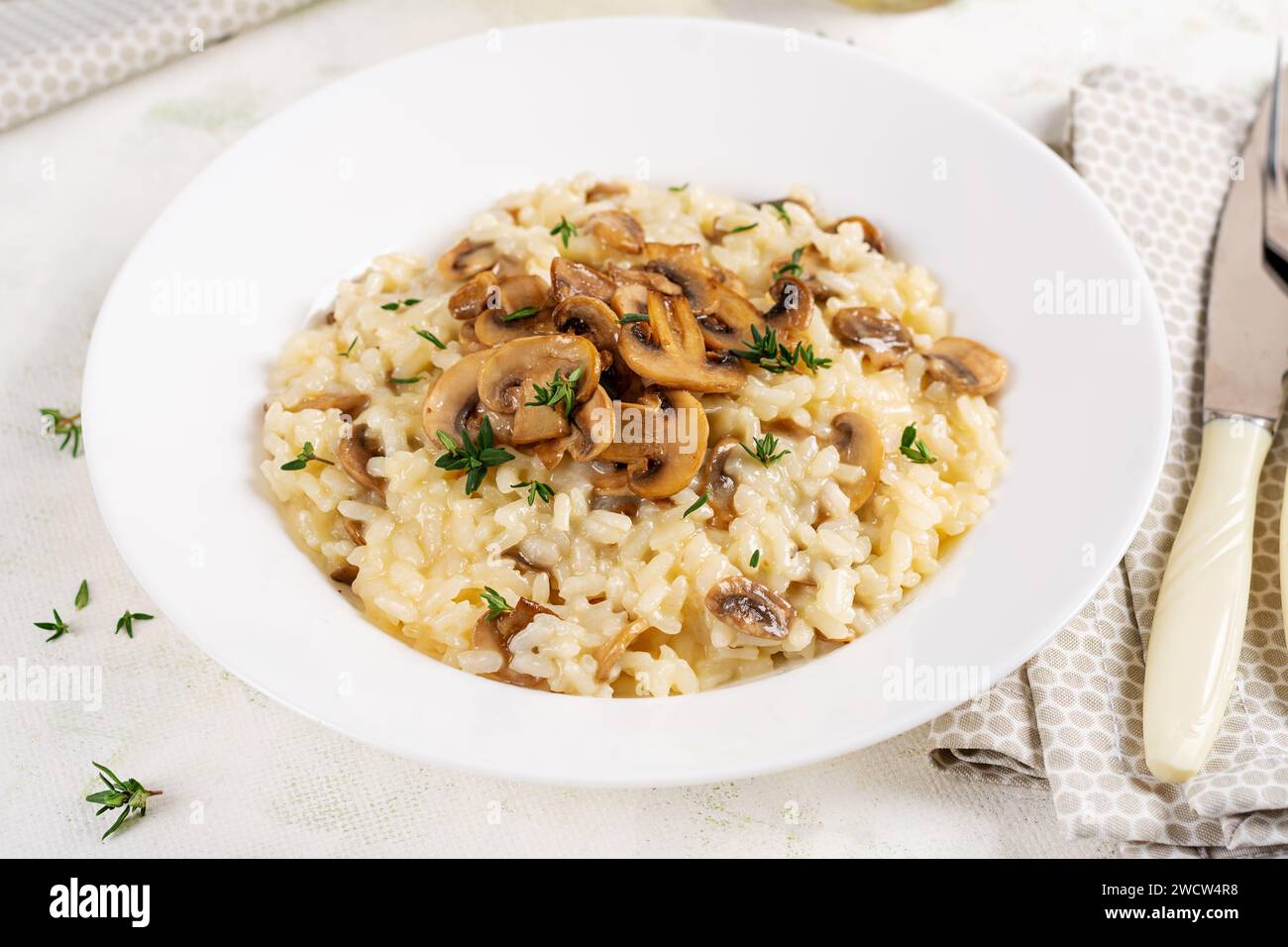 Piatto con delizioso risotto con funghi in piatto. Porridge di riso con fungo e tmyne. Piatti caldi, cucina italiana. Foto Stock