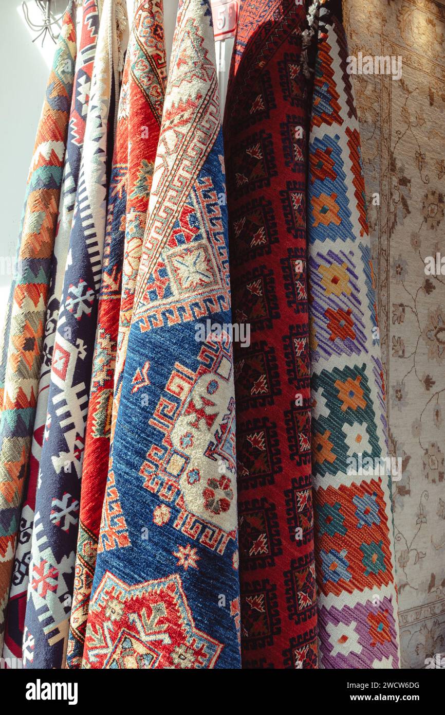 Dettaglio ravvicinato dei kilim turchi decorati con accattivanti motivi orientali, esposti in un negozio del Grand Bazaar Foto Stock