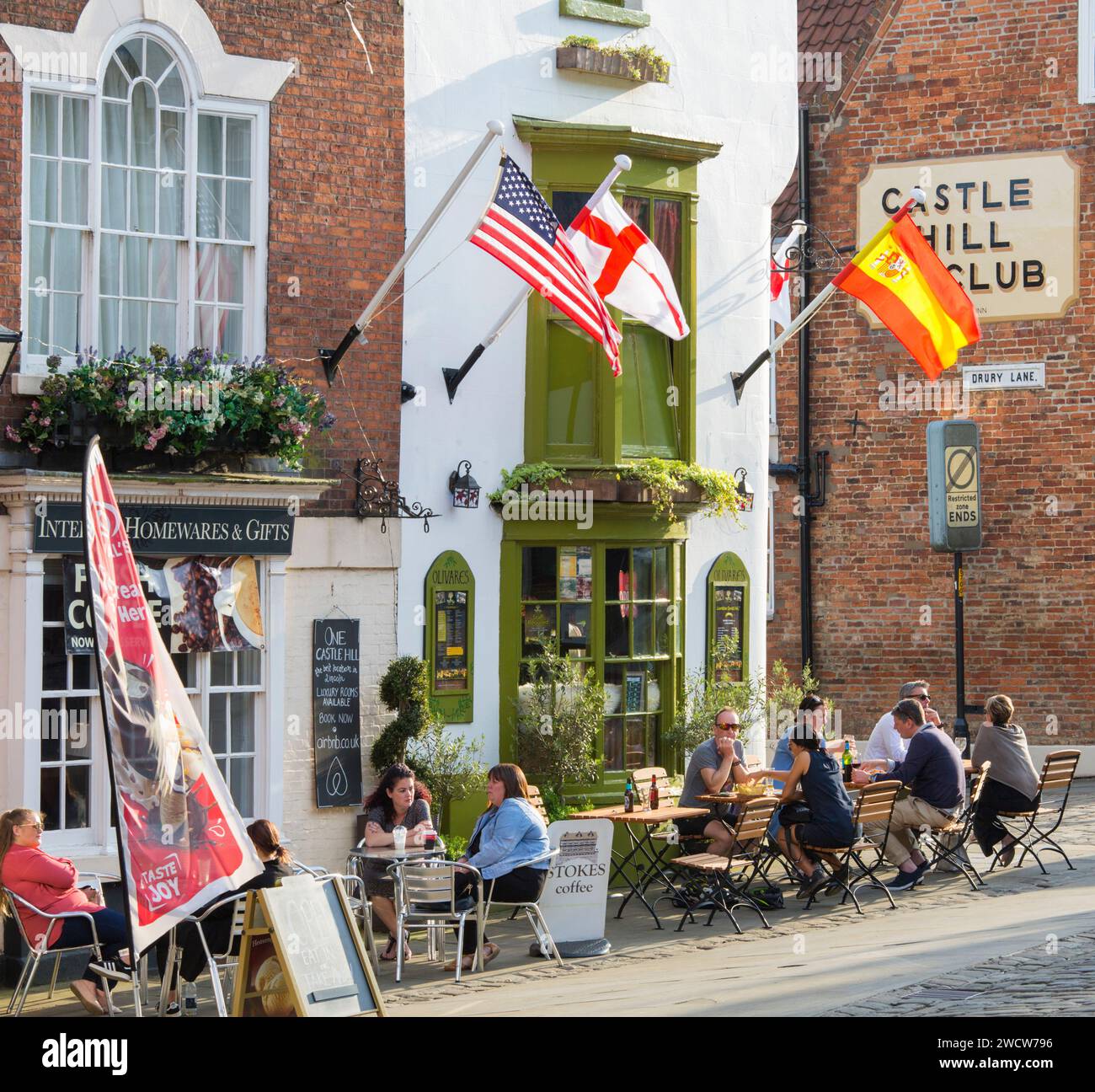 Lincoln, Lincolnshire, Inghilterra. I clienti si rilassano sulla terrazza soleggiata di Olivares, un popolare ristorante di tapas in Piazza del Castello. Foto Stock