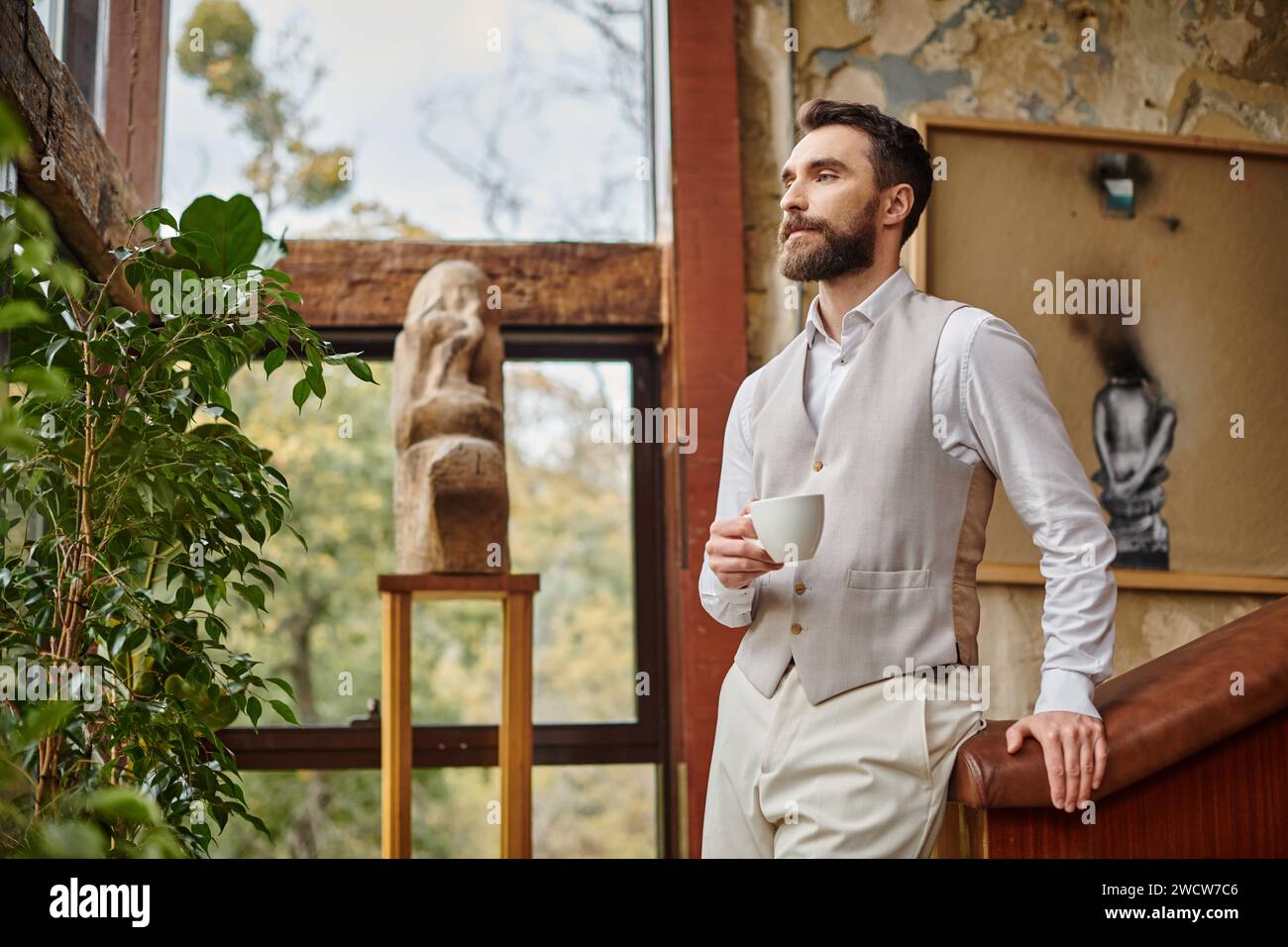 leader d'affari alla moda concentrato con barba con stile elegante bevendo il suo caffè Foto Stock