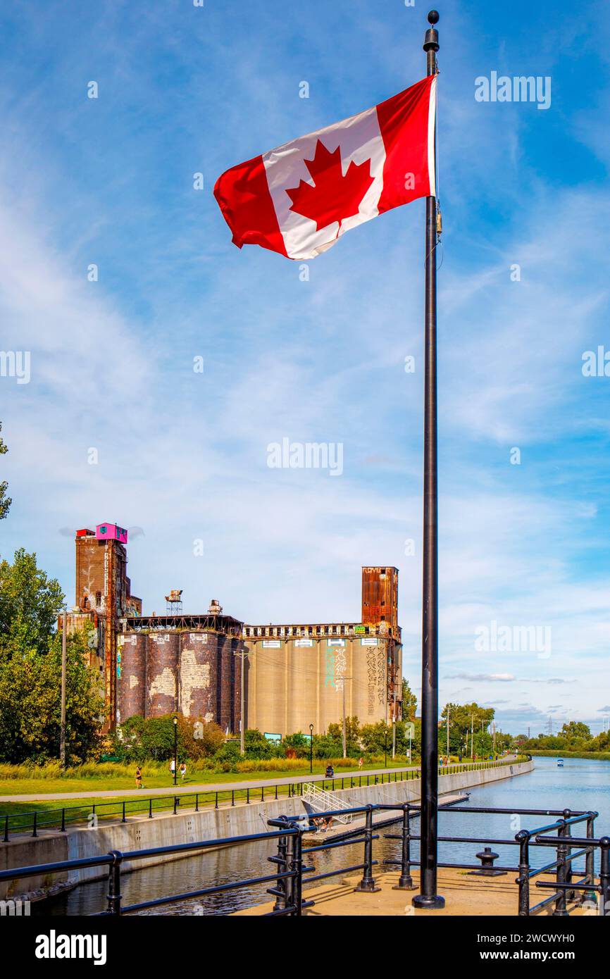 Canada, provincia di Quebec, Montreal, i dintorni del canale Lachine nella parte occidentale della città, i silos dell'ex fabbrica Canada Malting Co, serratura e bandiera del Canada Foto Stock