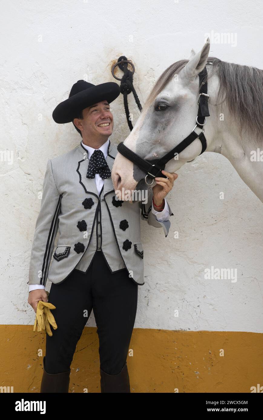 Spagna, Andalusia, Jerez de la Frontera, scuola reale andalusa di arte equestre, cavaliere in costume di Goyesque accanto a un cavallo bianco Foto Stock