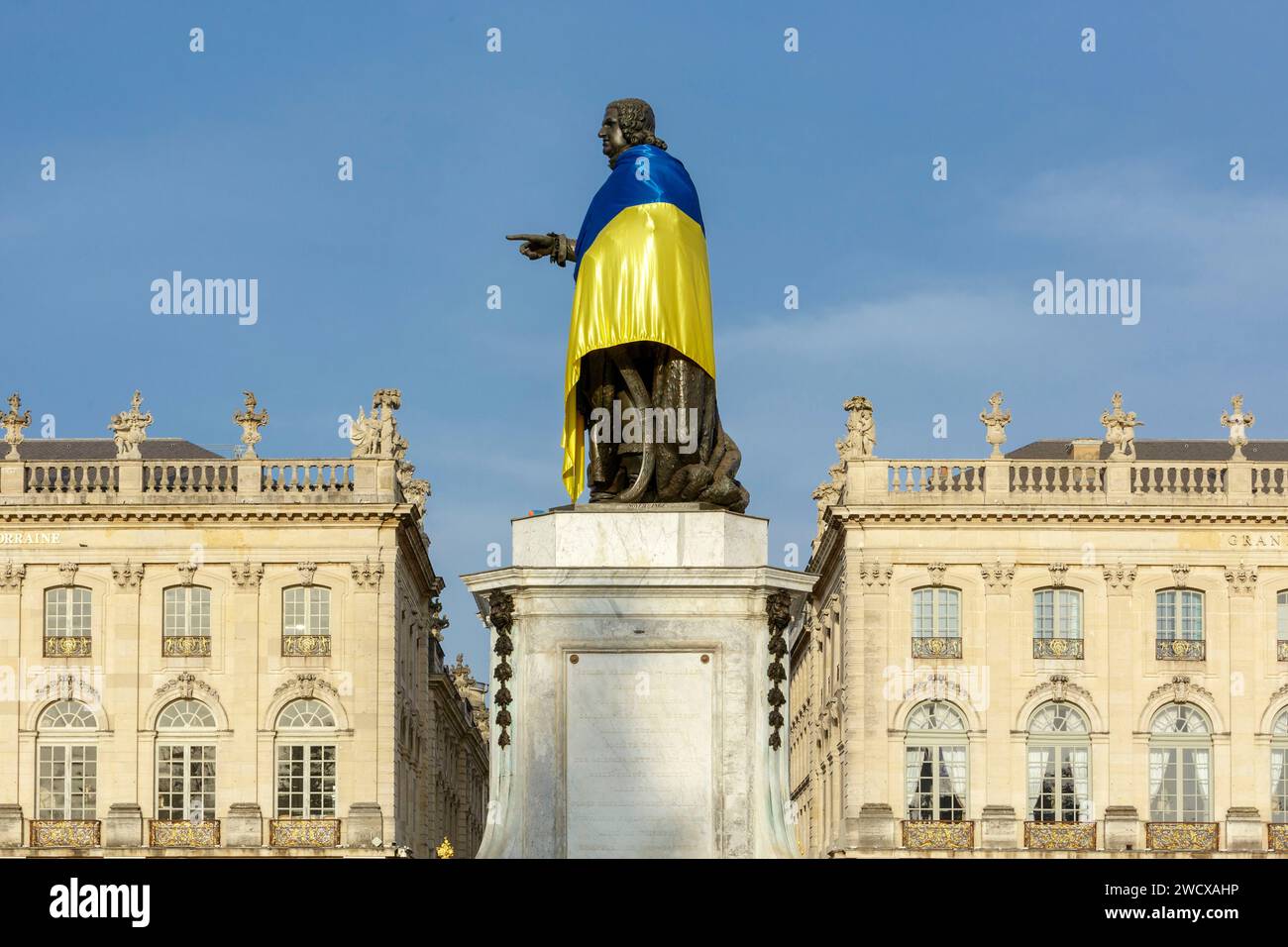 Francia, Meurthe et Moselle, Nancy, piazza Stanislas (ex piazza reale) costruita da Stanislas Leszczynski, re di Polonia e ultimo duca di Lorena nel XVIII secolo, patrimonio dell'umanità dell'UNESCO, facciate del Teatro dell'Opera (a sinistra) e del Grand Hotel de la Reine (a destra) e della statua di Stanislao con la bandiera di Ukrania Foto Stock