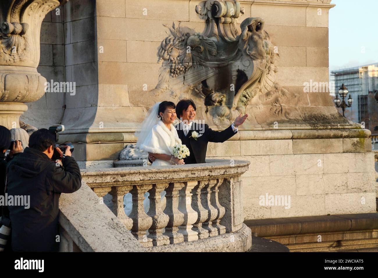 Francia, Parigi, sessione fotografica di una coppia asiatica sposata al tramonto sul ponte Alexandre III Foto Stock