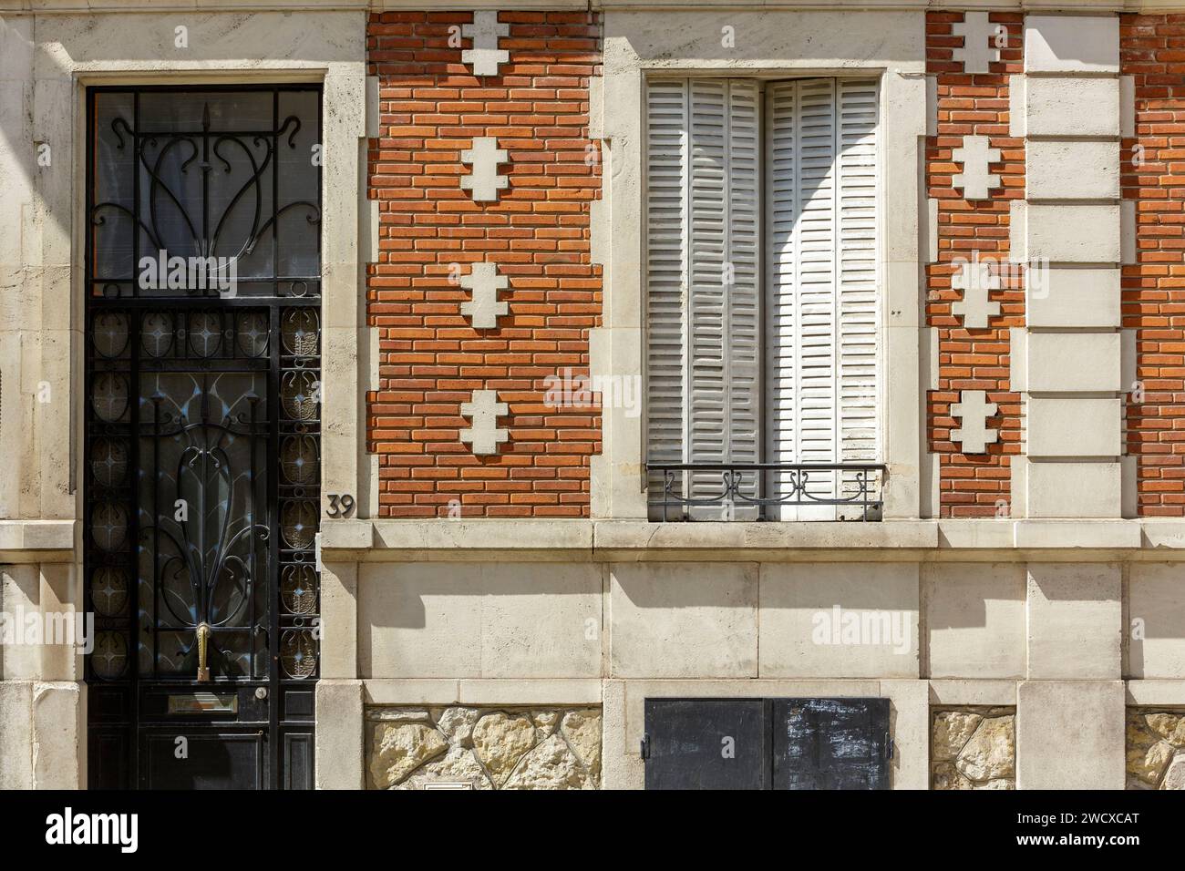 Francia, Meurthe et Moselle, Nancy, porta con ferri in ferro battuto e facciata di una casa in pietra e mattoni rossi con croci di Lorena come decorazioni sulla facciata in stile Art Nouveau situata in Rue Victor Hugo Foto Stock