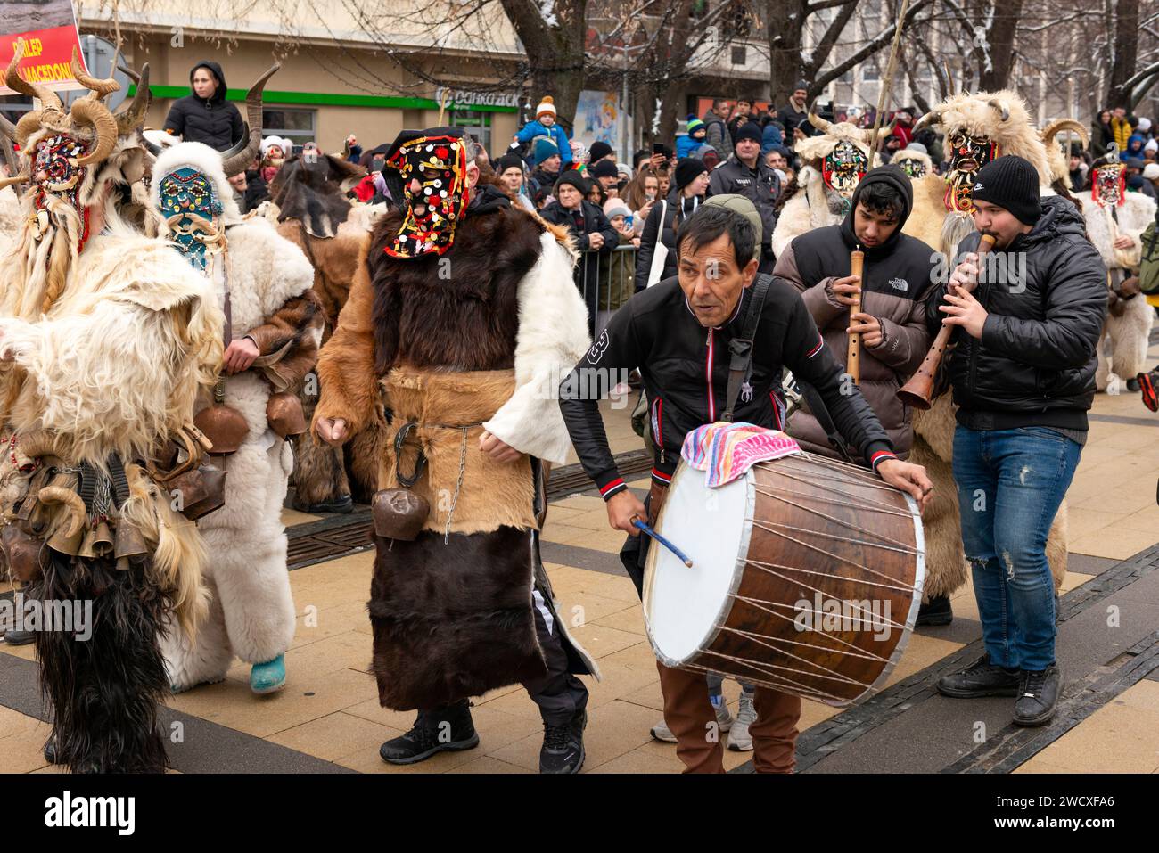 Musicisti gitani viaggiatori e Kukeri mascherato dalla Macedonia al Surva International Masquerade and Mummers Festival di Pernik, Bulgaria, Foto Stock
