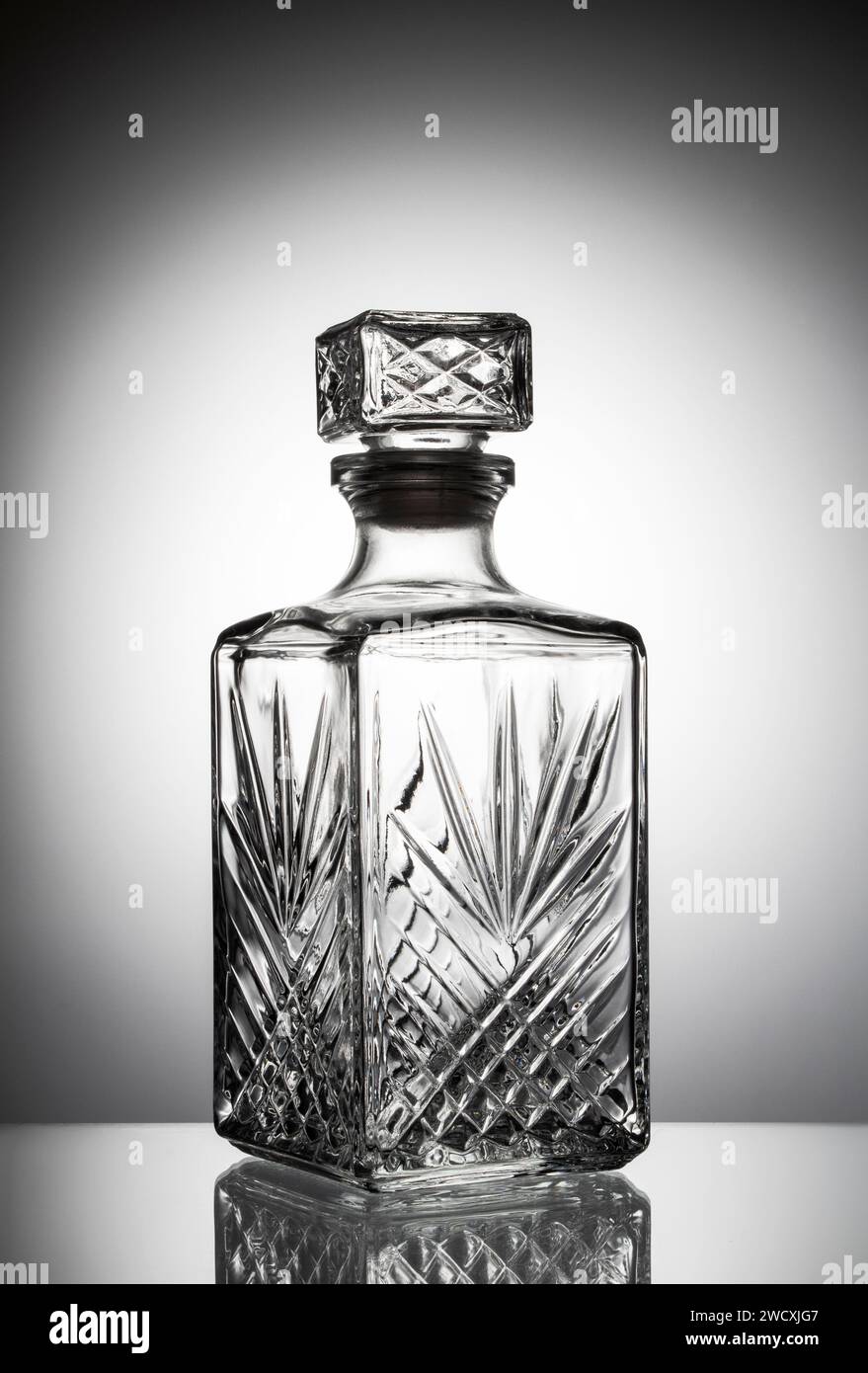 Decanter vuoto per whisky su sfondo bianco con sfumatura scura negli angoli superiori dell'immagine. Foto Stock