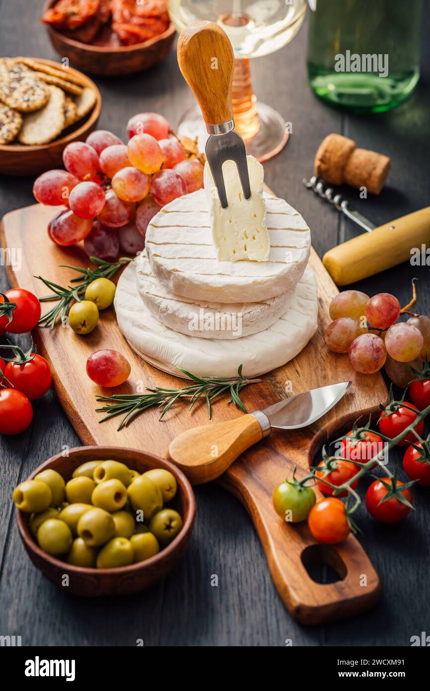 Piatto di formaggi con brie, Camembert, uva, olive e pomodori Foto Stock