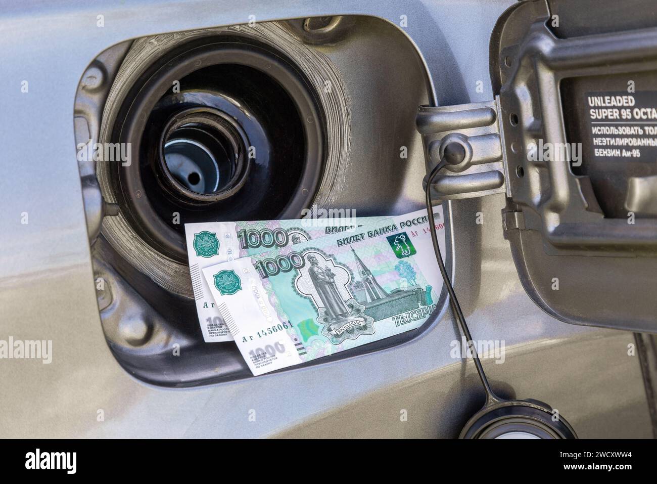 Banconote rubli russi nel serbatoio del gas di un veicolo. Foto del concetto dell'aumento del prezzo del carburante. Risparmio di carburante. Elevato costo del carburante Foto Stock
