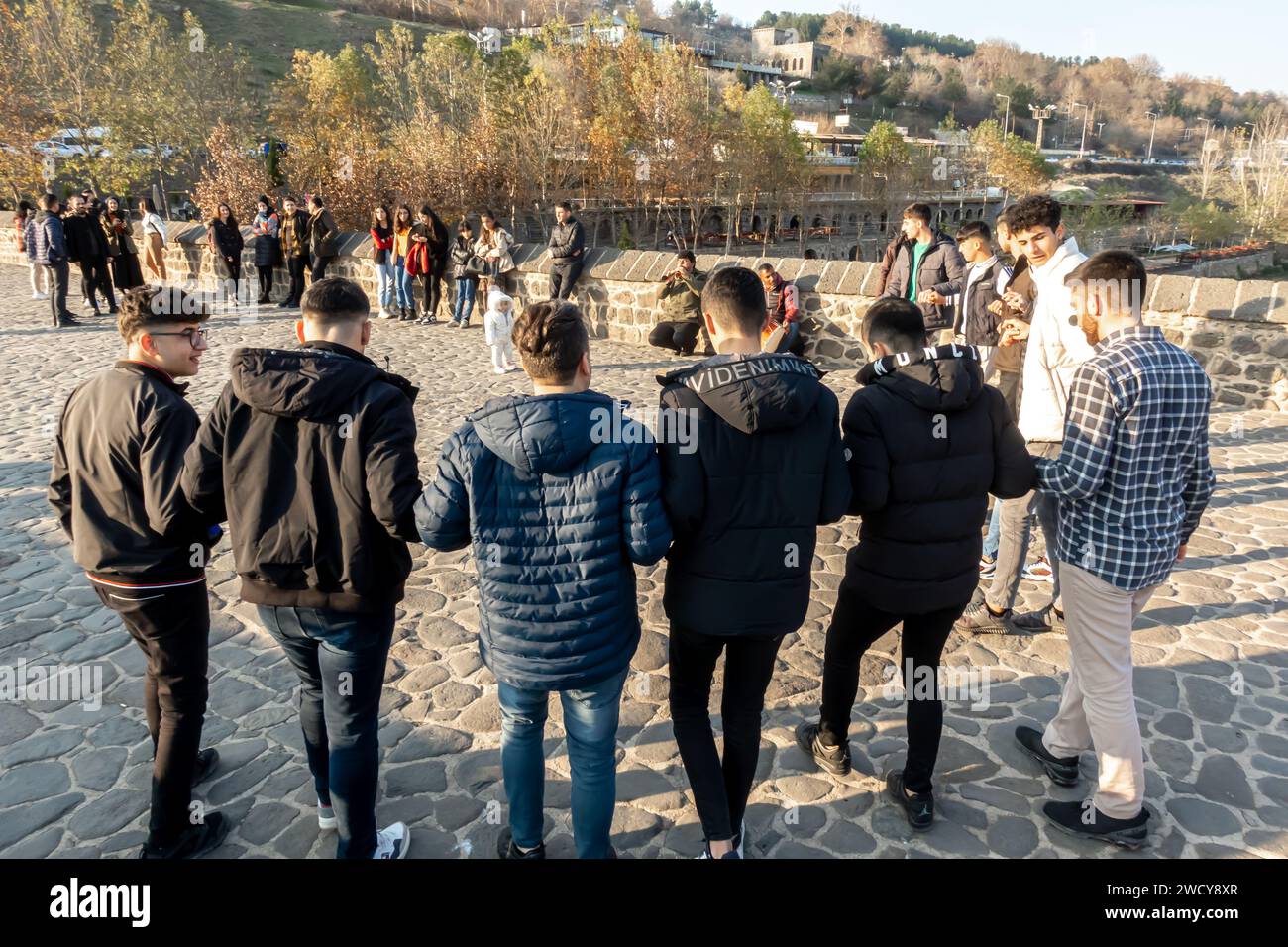 Danza tradizionale curda o danza tradizionale turca Halay. Gli uomini curdi eseguono danze spontanee sul ponte Diyarbakir in Turchia Foto Stock