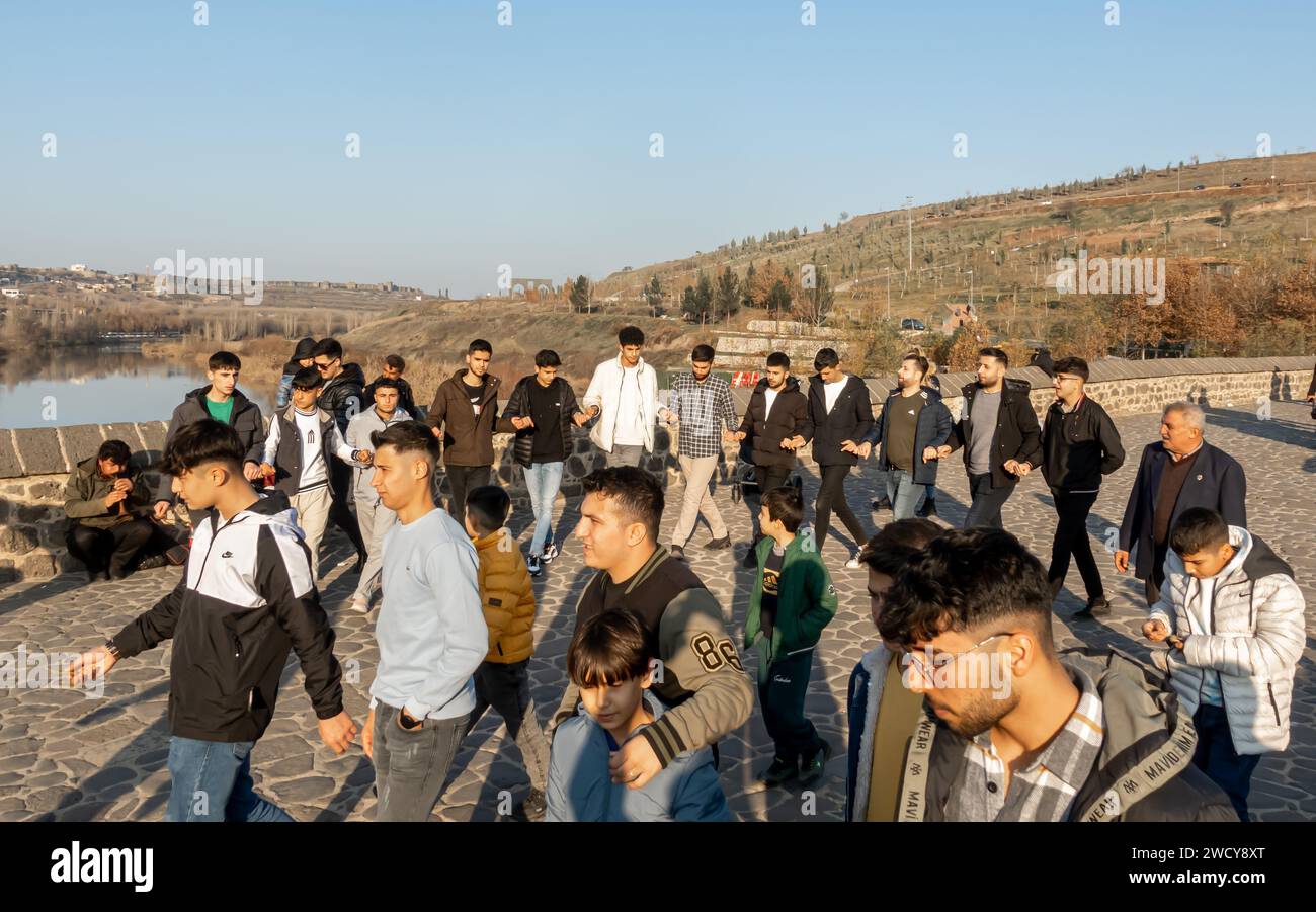 Danza tradizionale curda o danza tradizionale turca Halay. Gli uomini curdi eseguono danze spontanee sul ponte Diyarbakir in Turchia Foto Stock