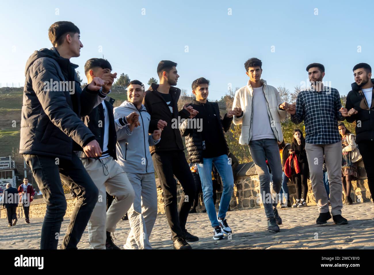 Danza tradizionale curda o danza tradizionale turca Halay. Gli uomini curdi eseguono danze spontanee sul ponte Diyarbakir in Turchia Foto Stock