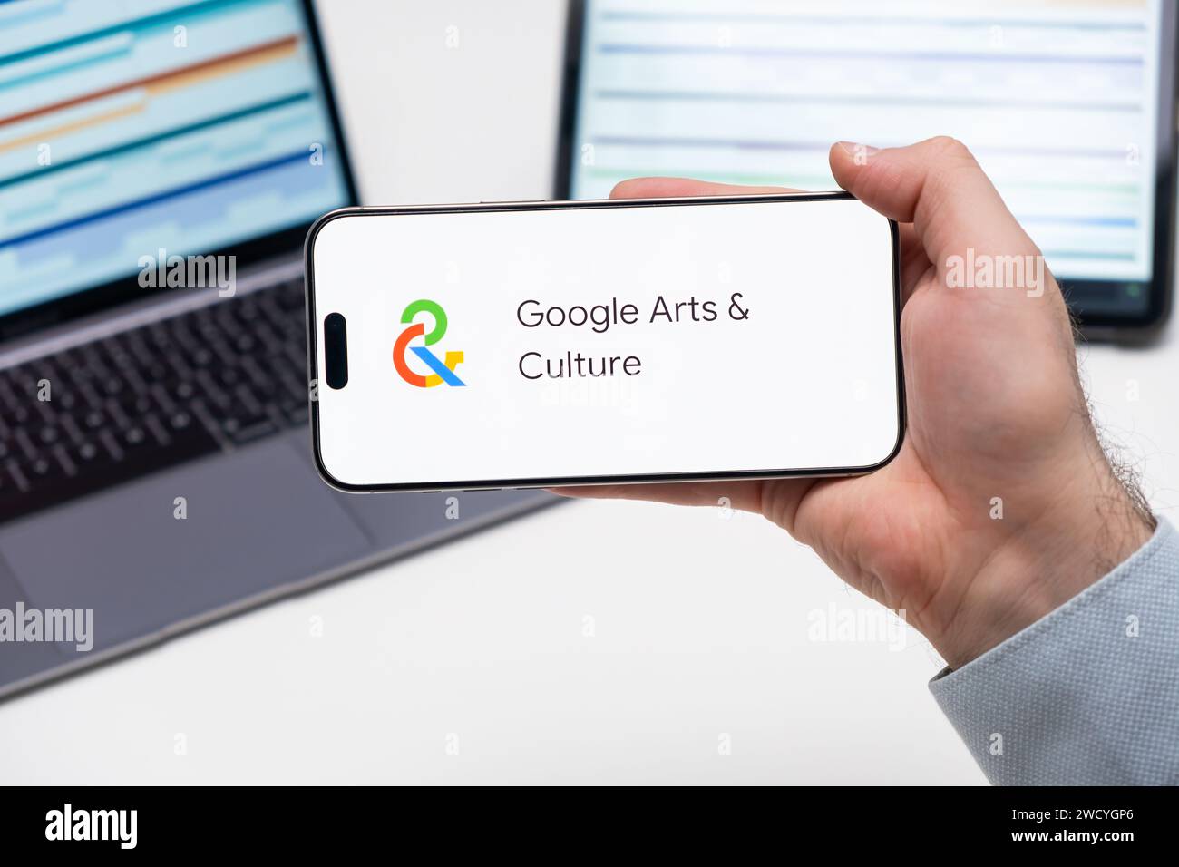 Il logo dell'applicazione Google Arts and Culture sullo schermo dello smartphone in mans Hand, laptop e tablet è sul tavolo in background, dicembre 2023, Praga, Repubblica Ceca. Foto Stock