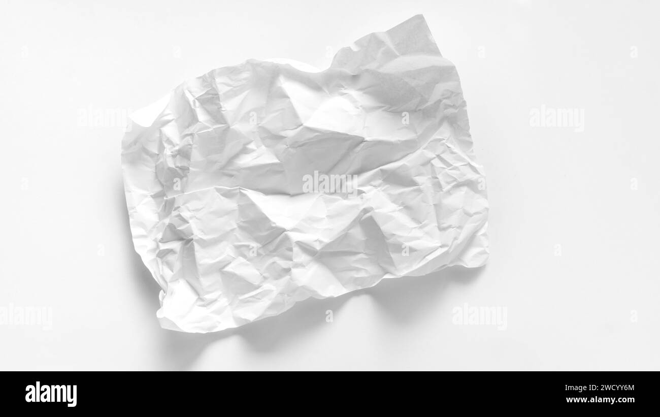 Primo piano di un foglio di carta asimmetrico e pesantemente schiacciato su sfondo bianco. Foglio di carta A4 schiacciato con spazio per la copia. Mockup con un foglio schiacciato Foto Stock