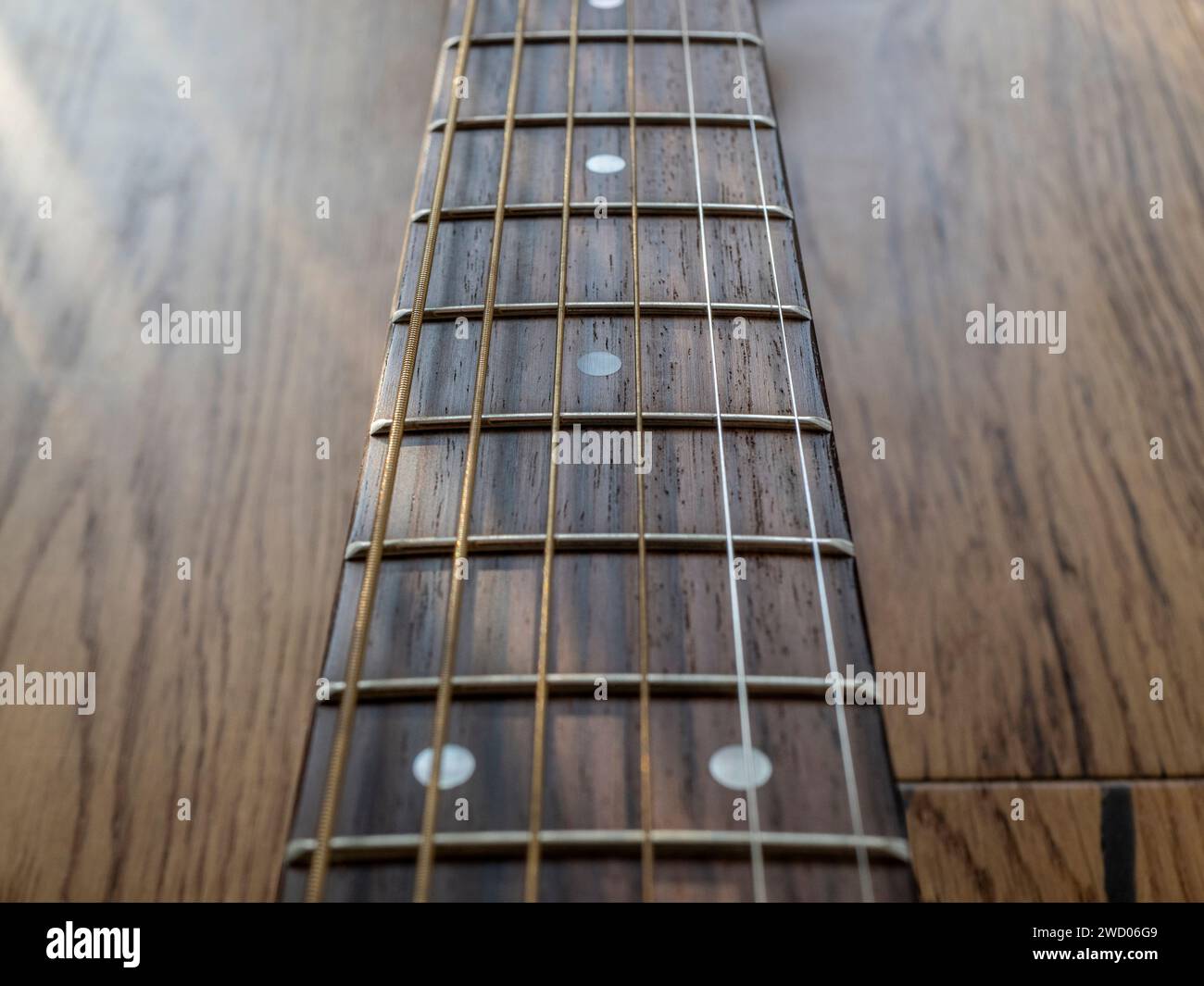 Sfondo con un motivo musicale che raffigura il collo di una chitarra. Profondità di campo ridotta. Sfumature di marrone. Foto Stock
