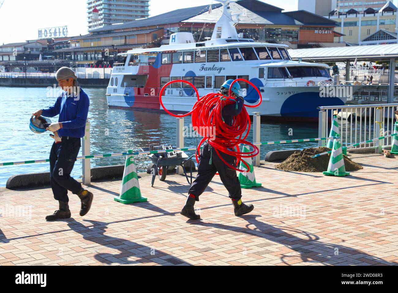 Lavoratori apanesi accanto al molo delle navi da crociera della baia di Kobe nella città di Kobe, prefettura di Hyogo, Giappone. Foto Stock