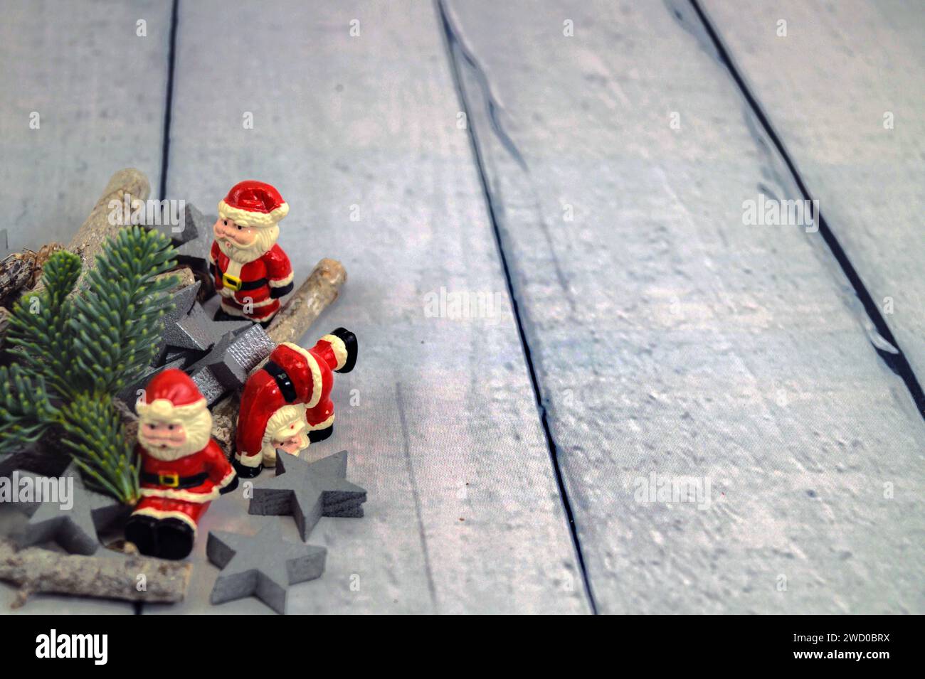 Decorazioni natalizie in stelle d'argento, bastoncini, rami di abete e clausole di Babbo Natale sul tavolo Foto Stock