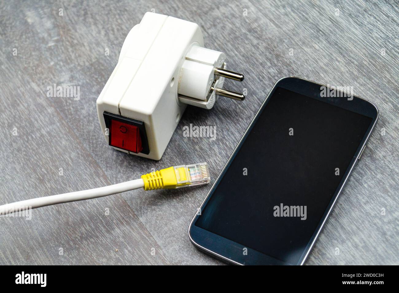 Adattatore presa con interruttore, smartphone e spina di rete, immagine simbolica per Smart Home Foto Stock
