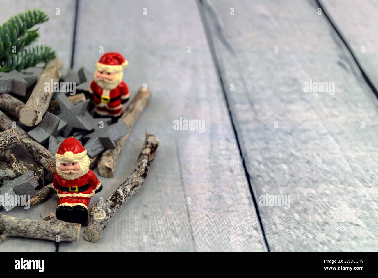 Decorazioni natalizie in stelle d'argento, bastoncini, rami di abete e clausole di Babbo Natale sul tavolo Foto Stock