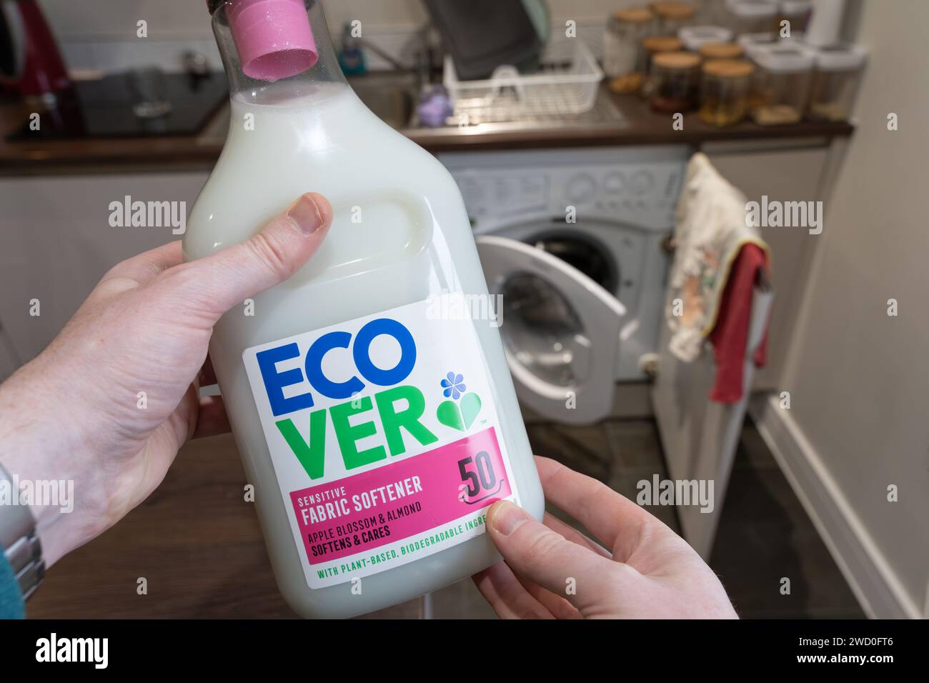 Mani che tengono una bottiglia di ammorbidente per tessuti ecologico con ingredienti biodegradabili a base vegetale di Ecover, un'azienda belga. REGNO UNITO Foto Stock